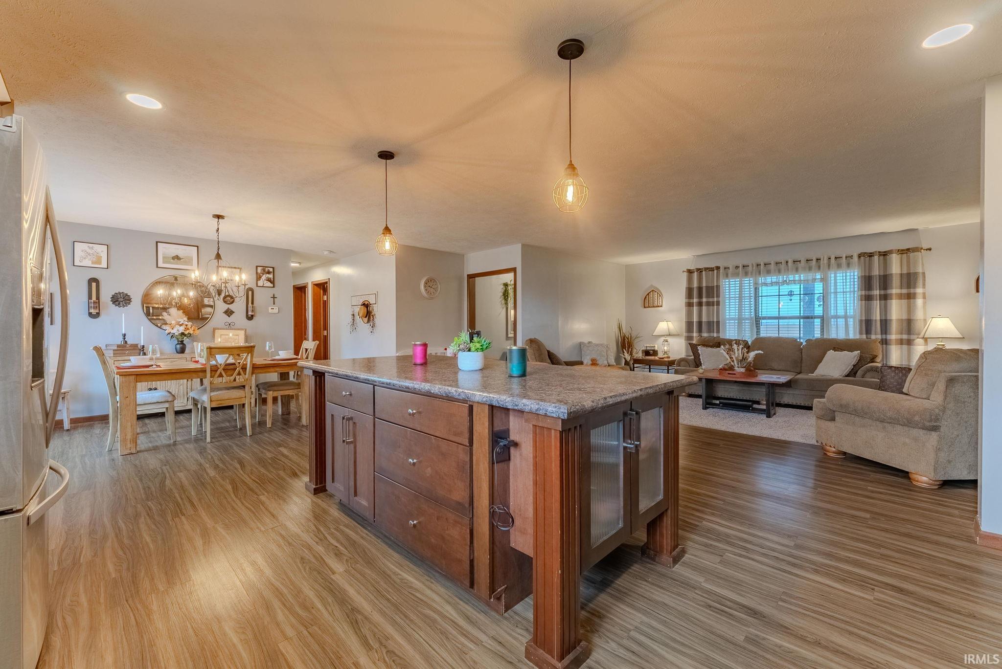 Kitchen with recessed lighting, stainless steel fridge with ice dispenser, pendant lighting, a center island, and open floor plan