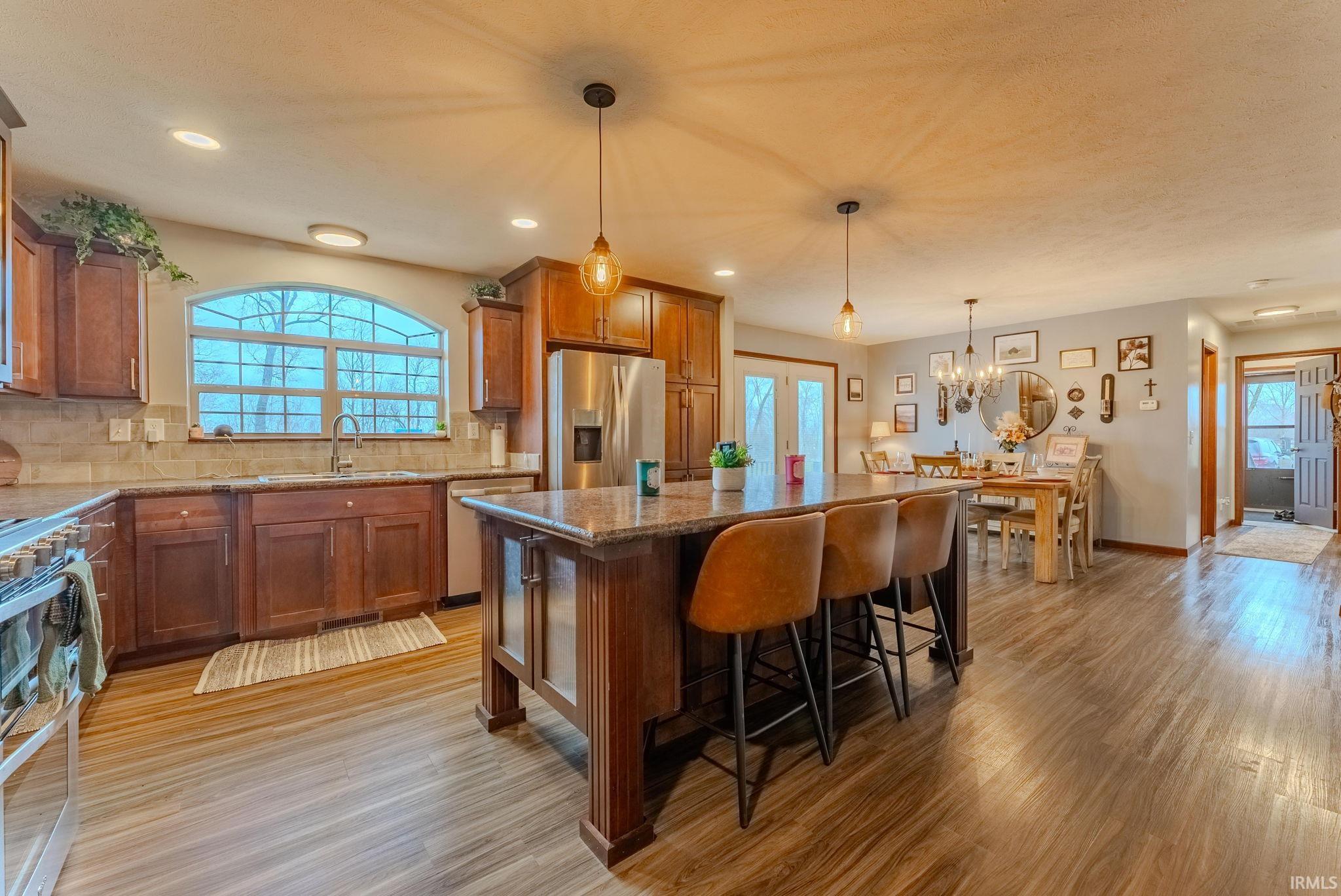 Kitchen with brown cabinetry, appliances with stainless steel finishes, healthy amount of natural light, and recessed lighting