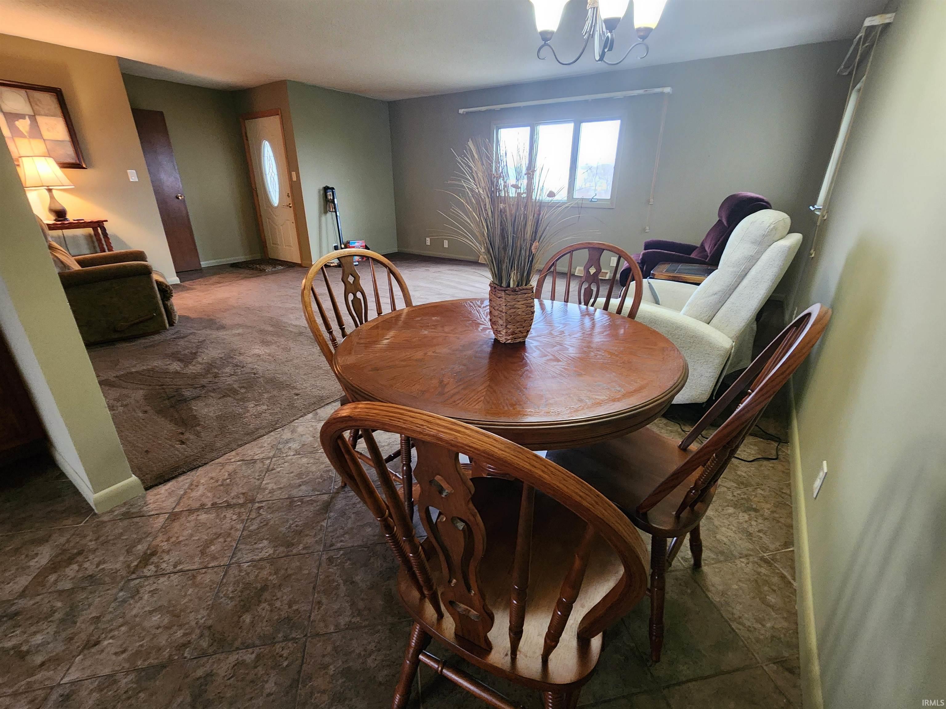 Dining space with a chandelier and baseboards