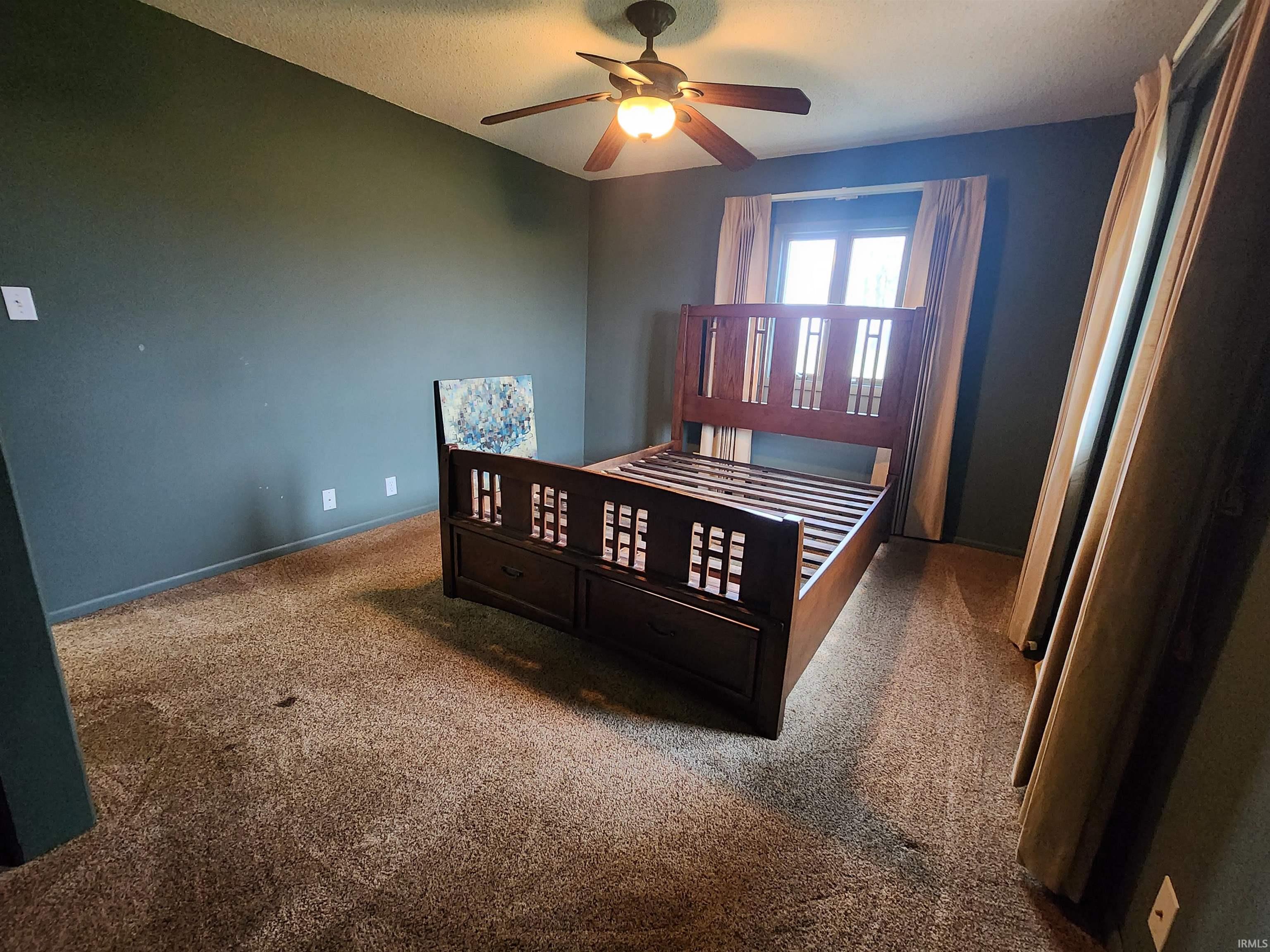 Carpeted bedroom featuring a ceiling fan and baseboards