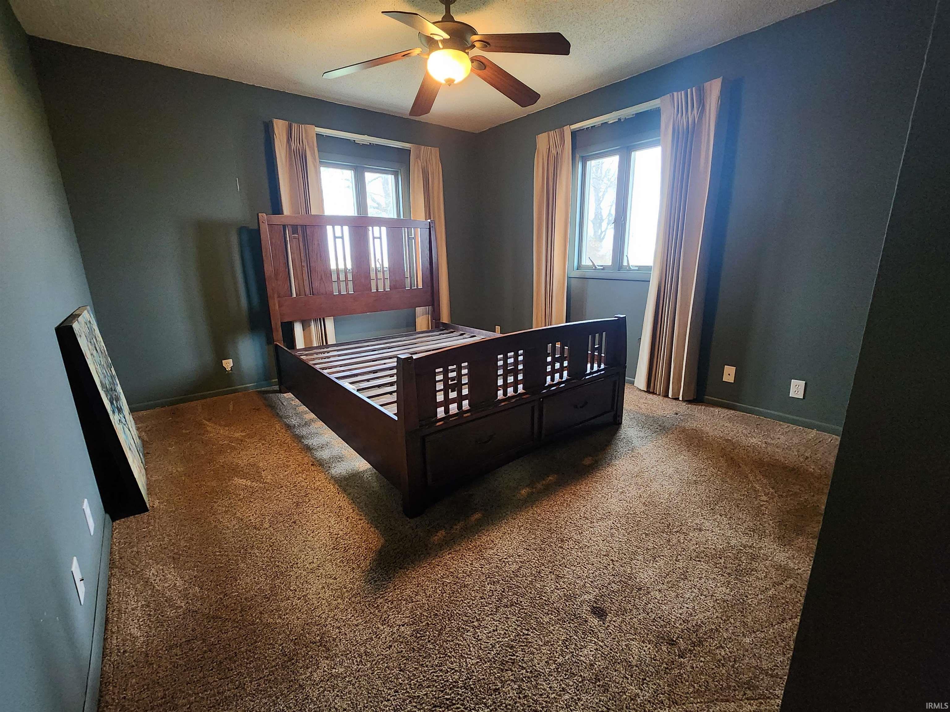 Bedroom featuring carpet floors, a ceiling fan, and a textured ceiling