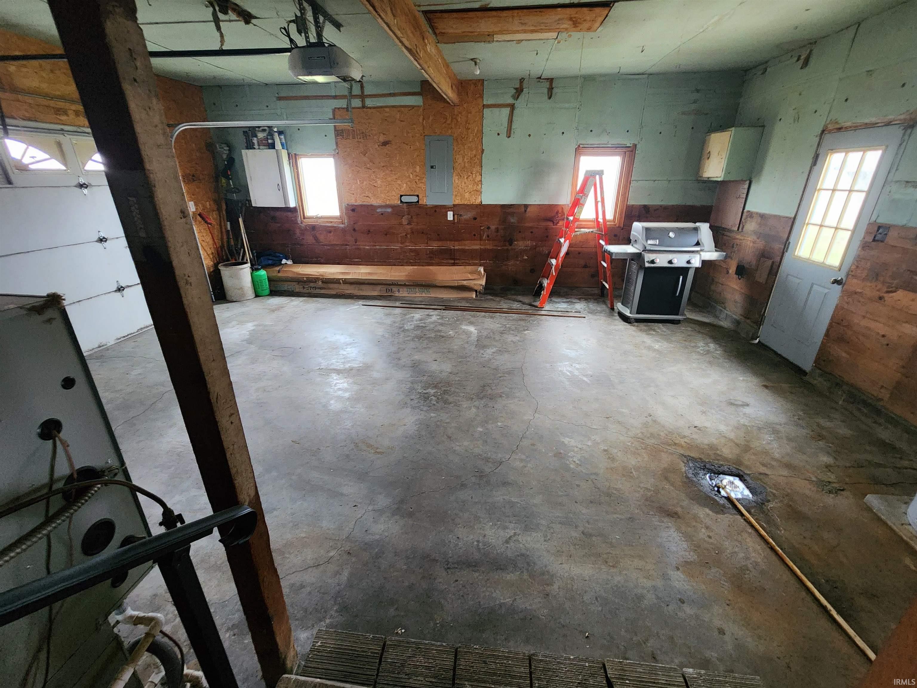 Garage featuring electric panel and a garage door opener