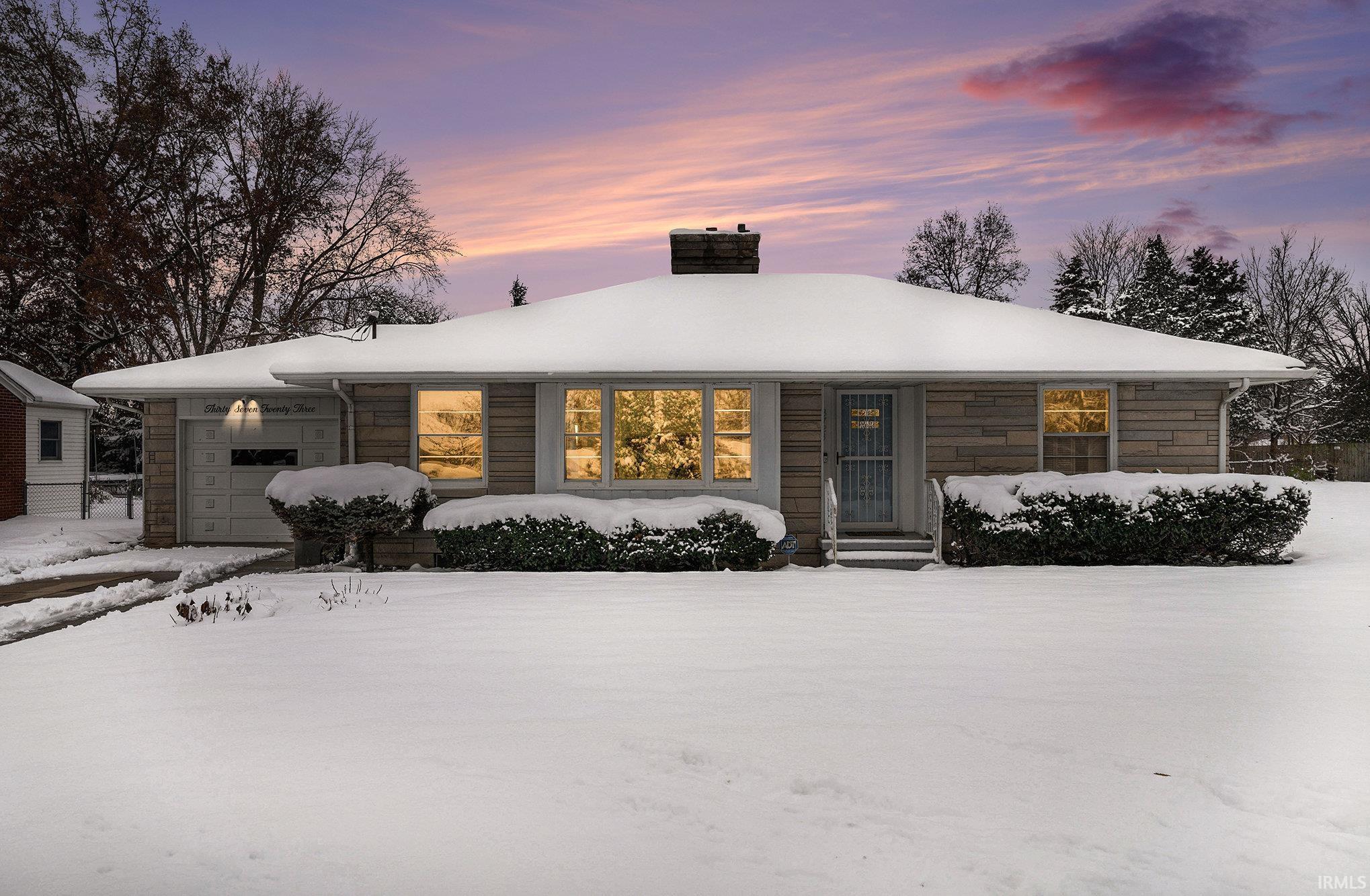 View of front of home with a chimney and stone siding