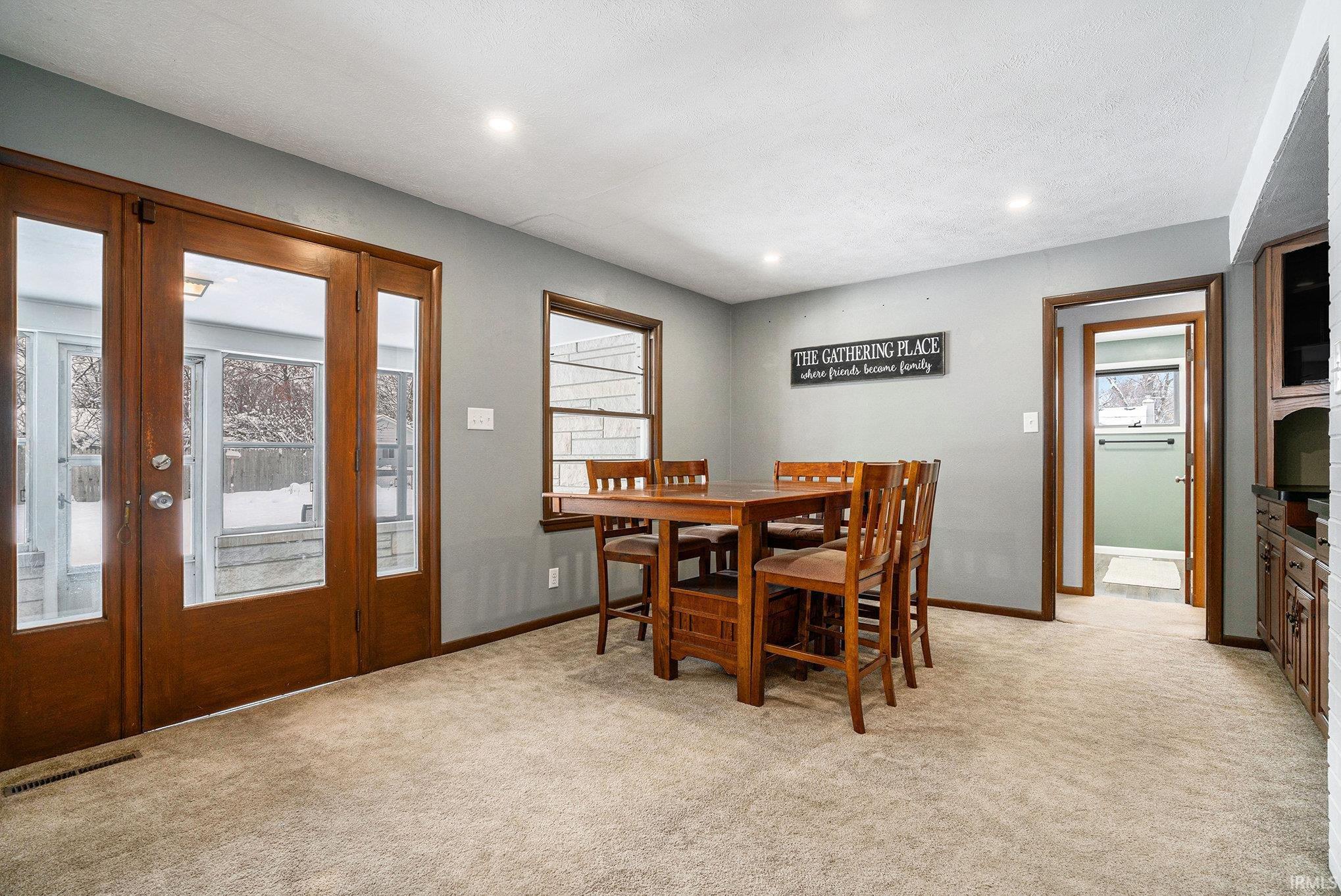 Dining room featuring plenty of natural light, light carpet, and recessed lighting