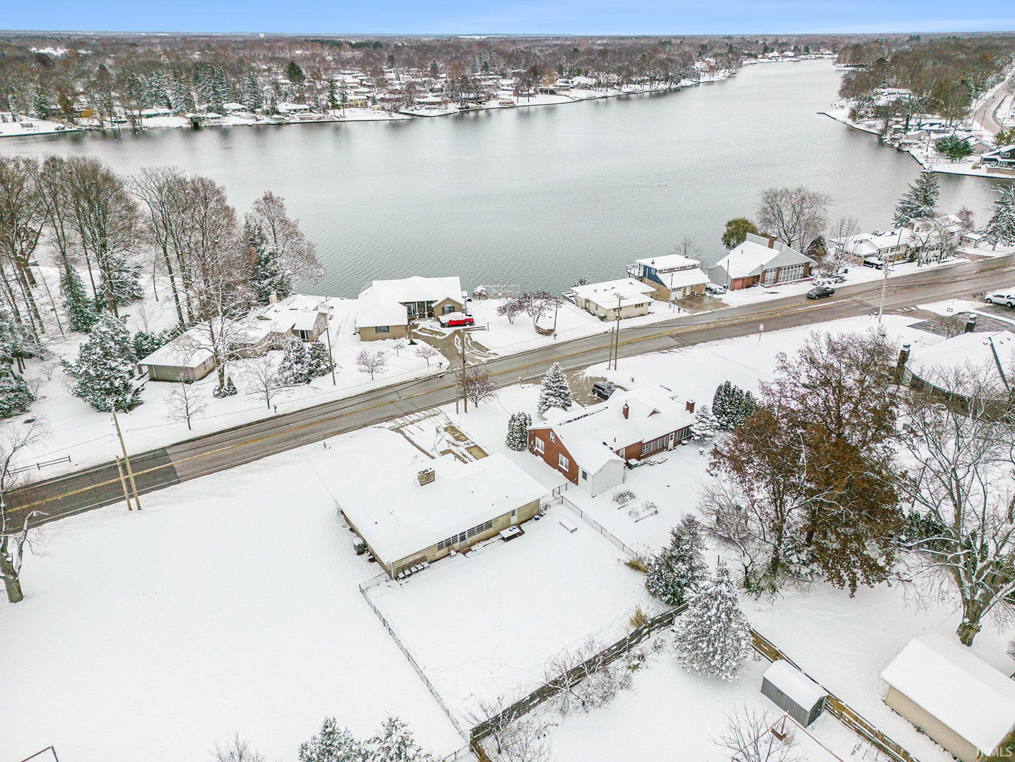 Snowy aerial view with a water view