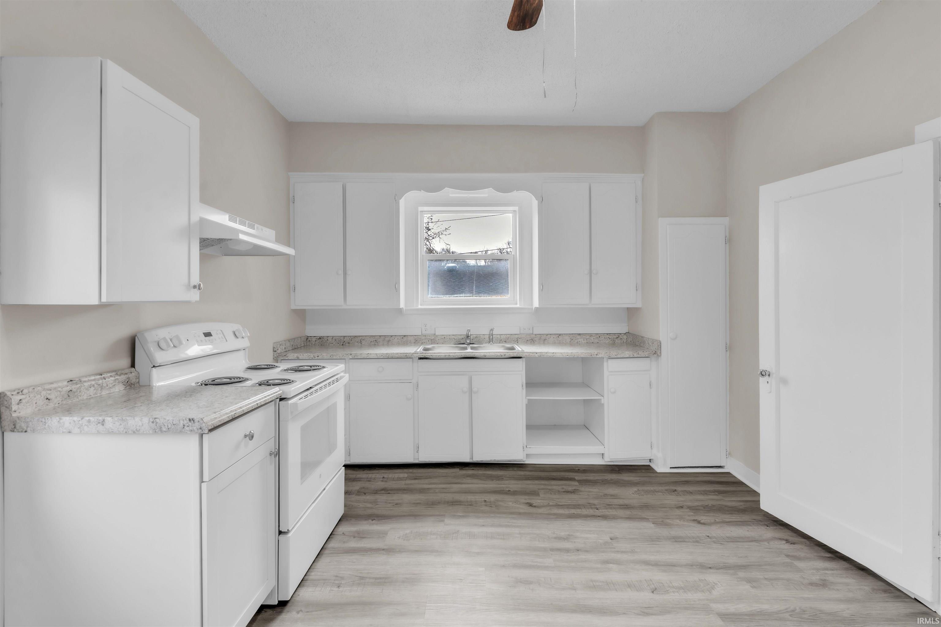 Kitchen featuring open shelves, white electric range, light countertops, and white cabinets