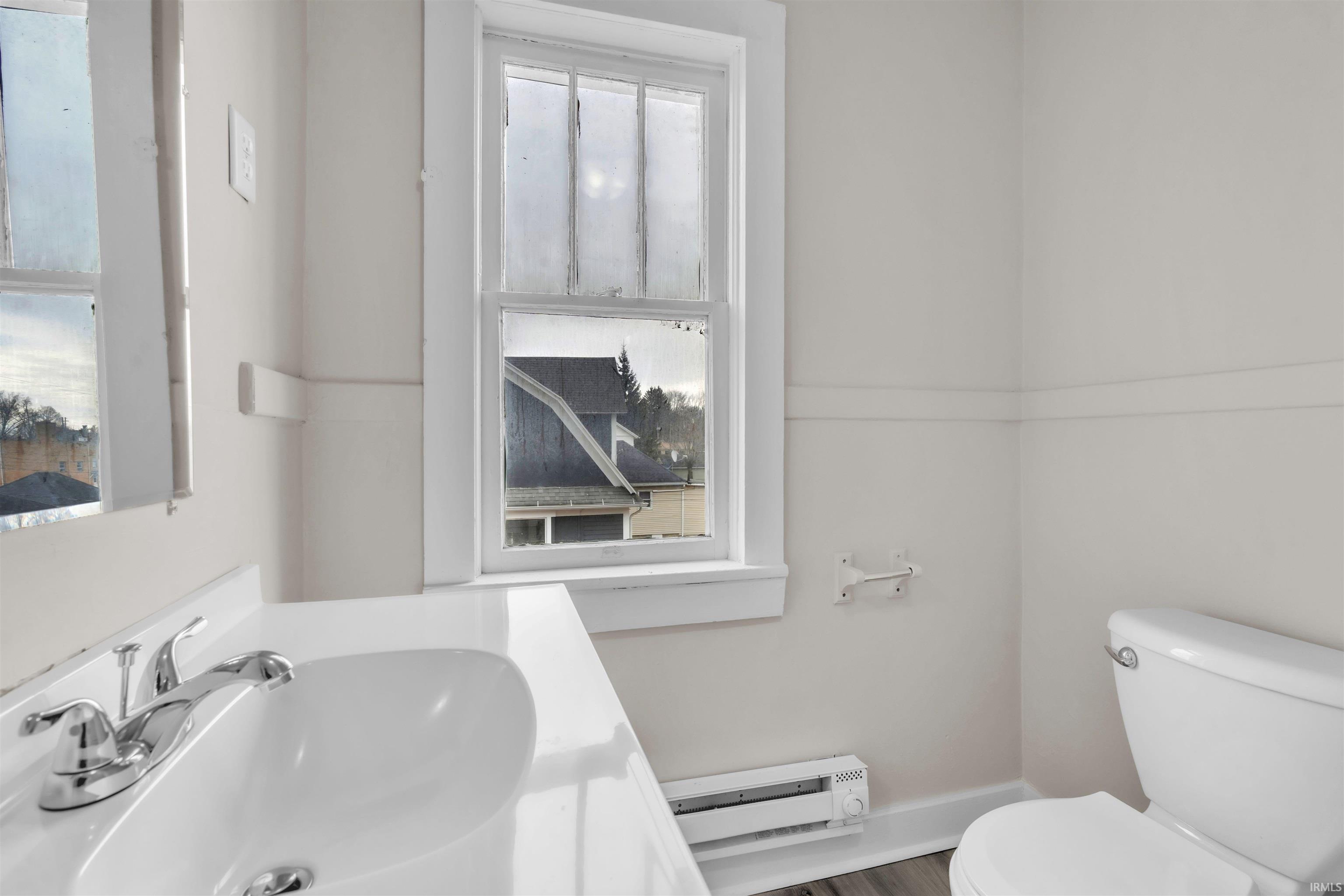 Half bathroom with vanity and a baseboard heating unit