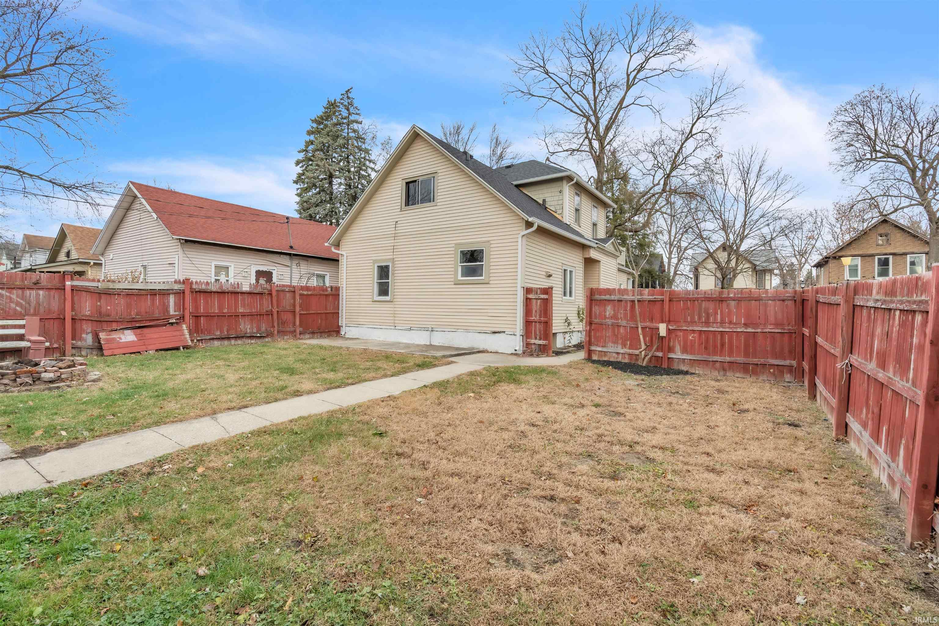 Rear view of house featuring a fenced backyard