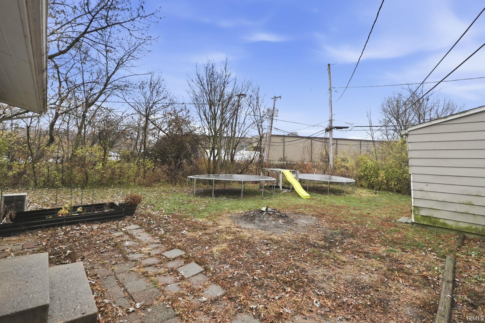 View of yard with a trampoline and a patio area