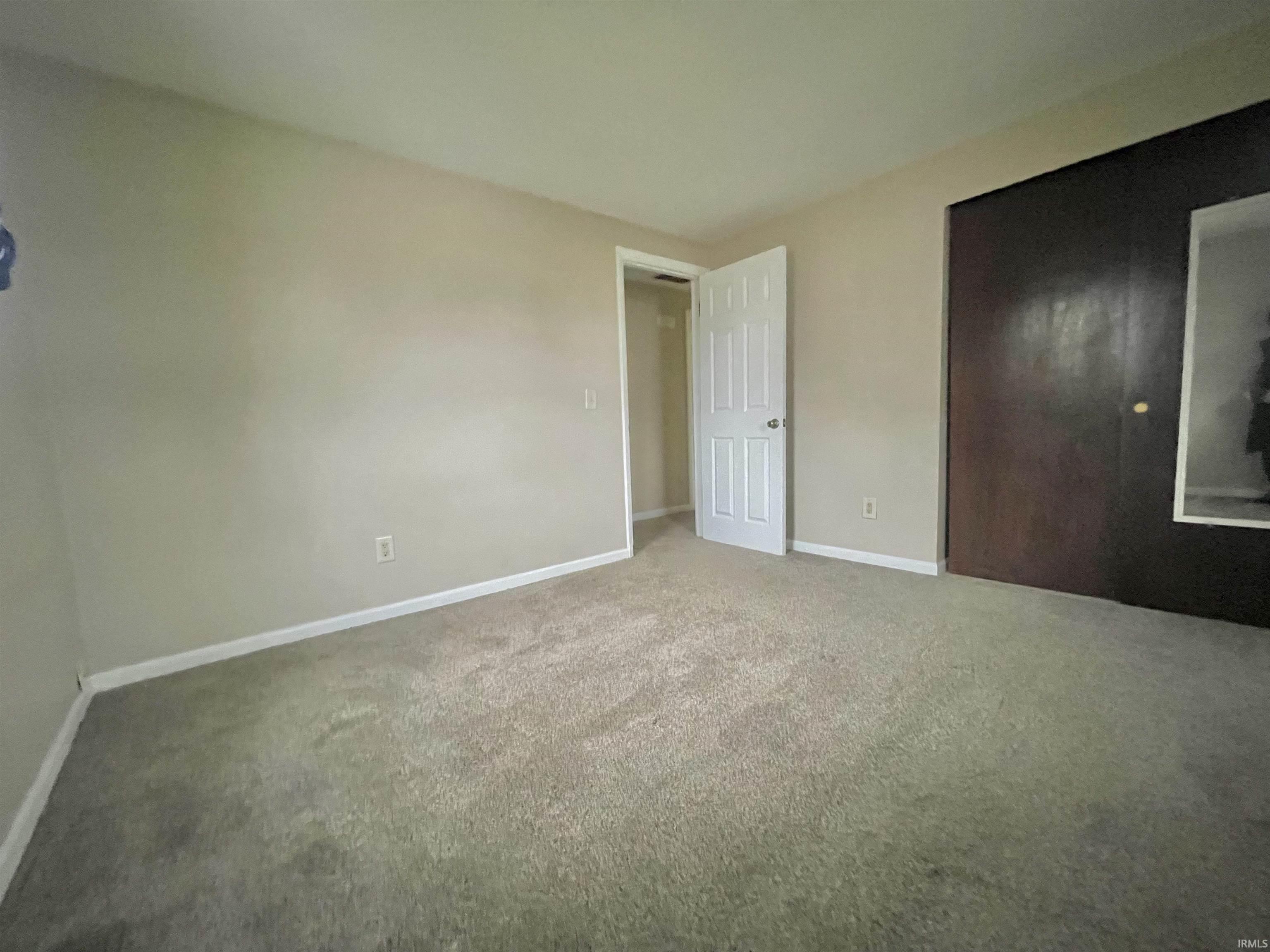 Unfurnished bedroom featuring carpet and a closet