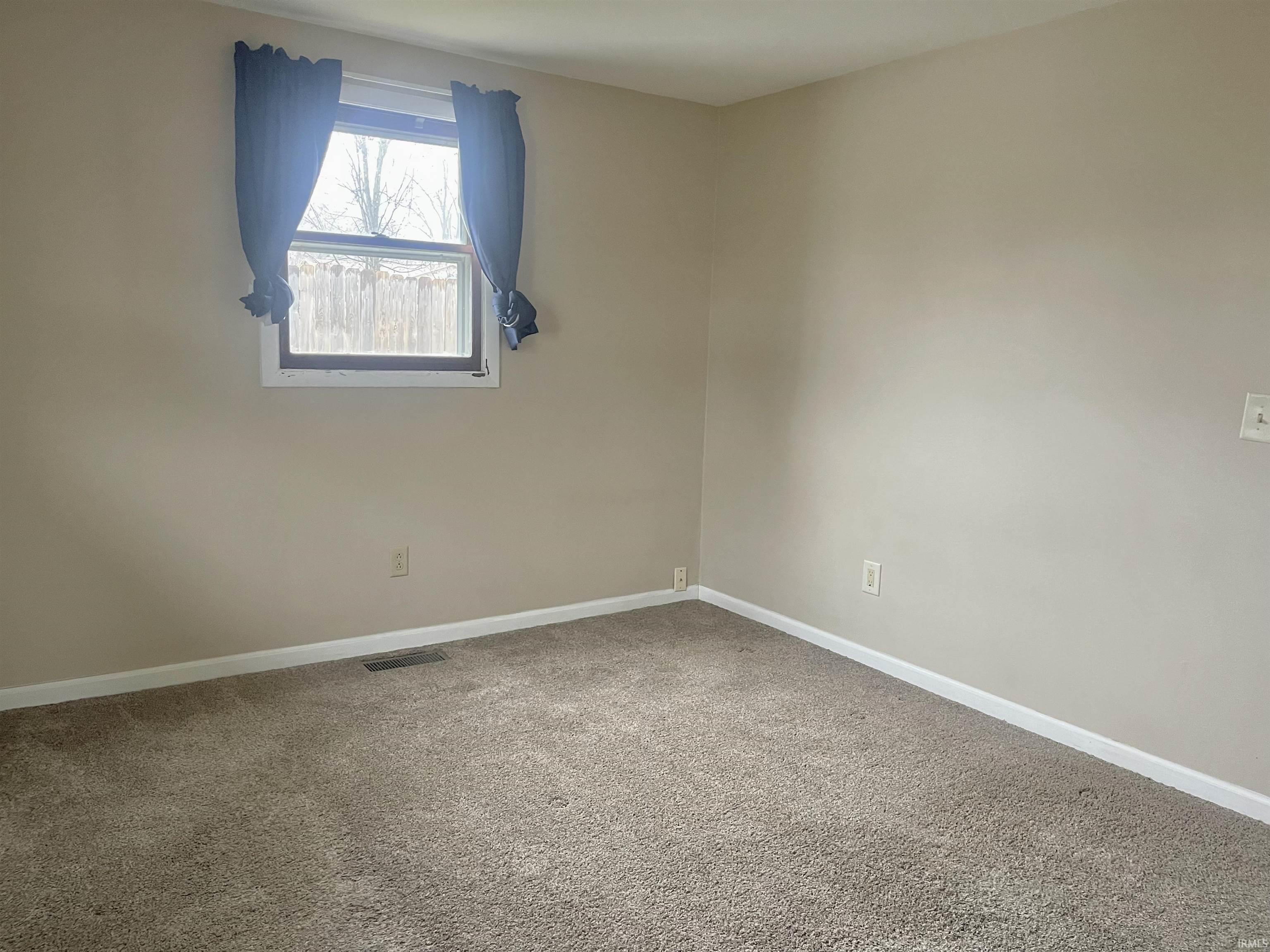 Spare room with carpet and baseboards
