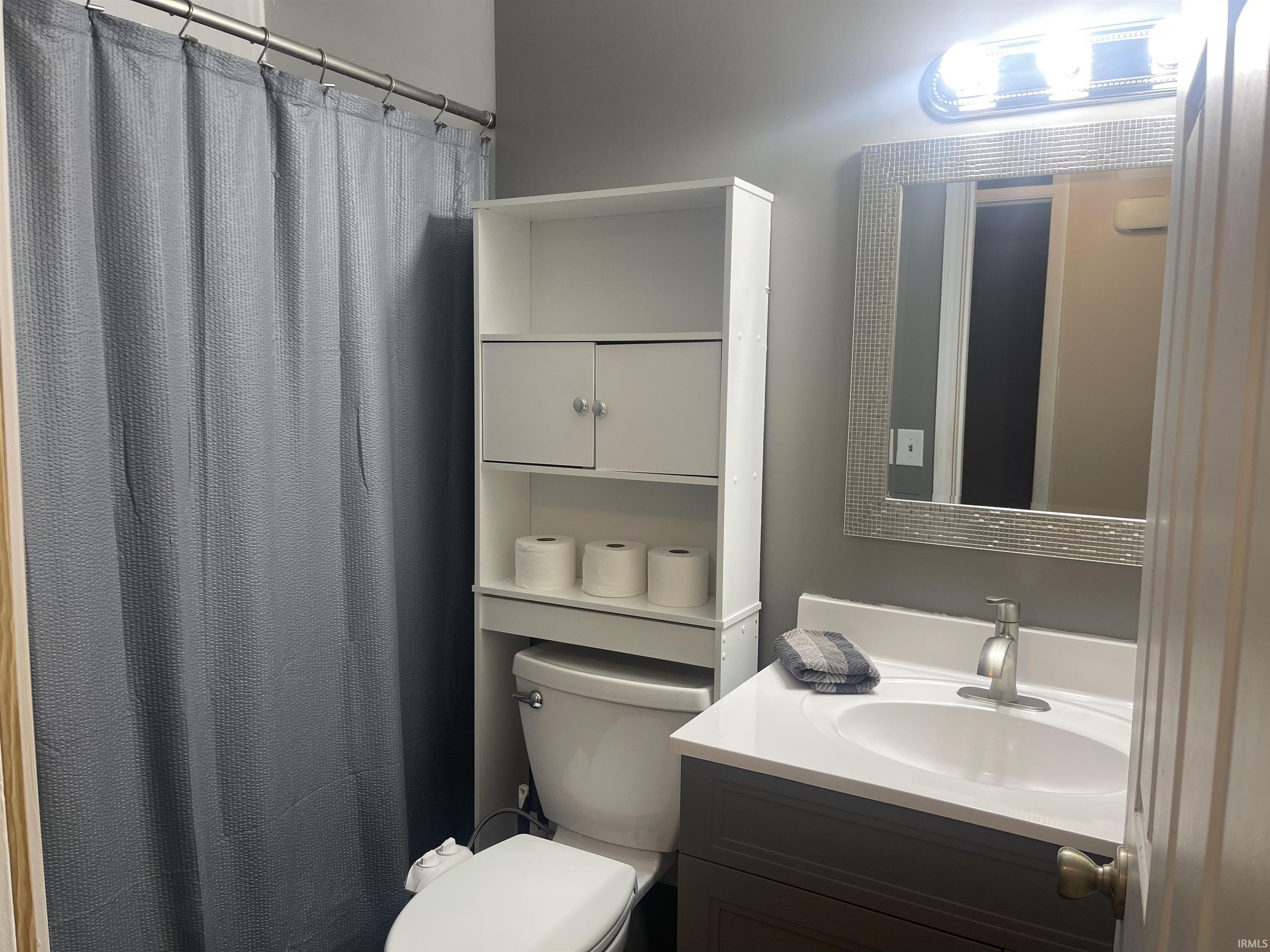 Bathroom with curtained shower and vanity