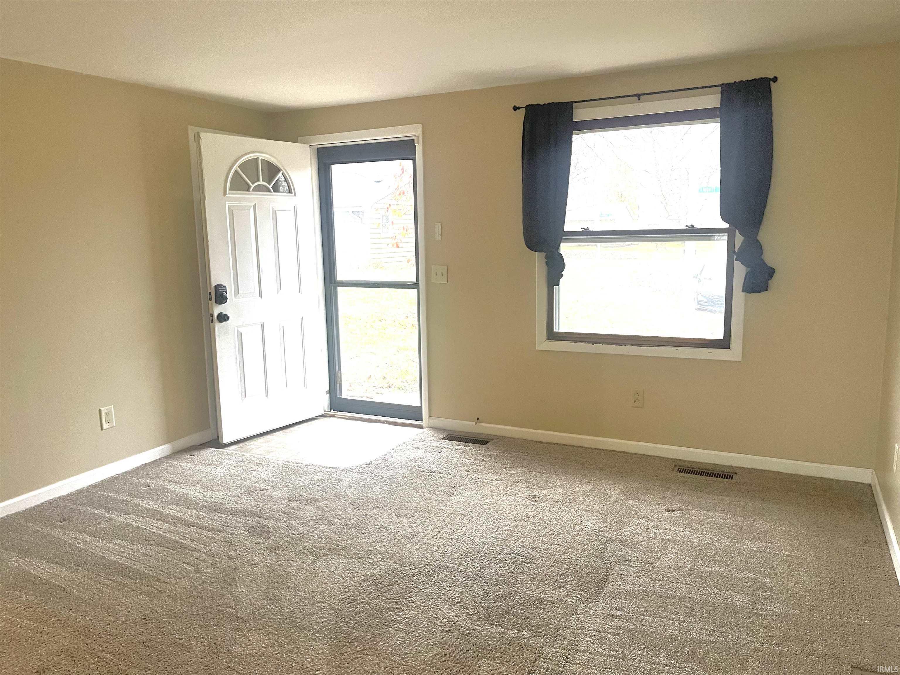 Foyer with baseboards and carpet floors