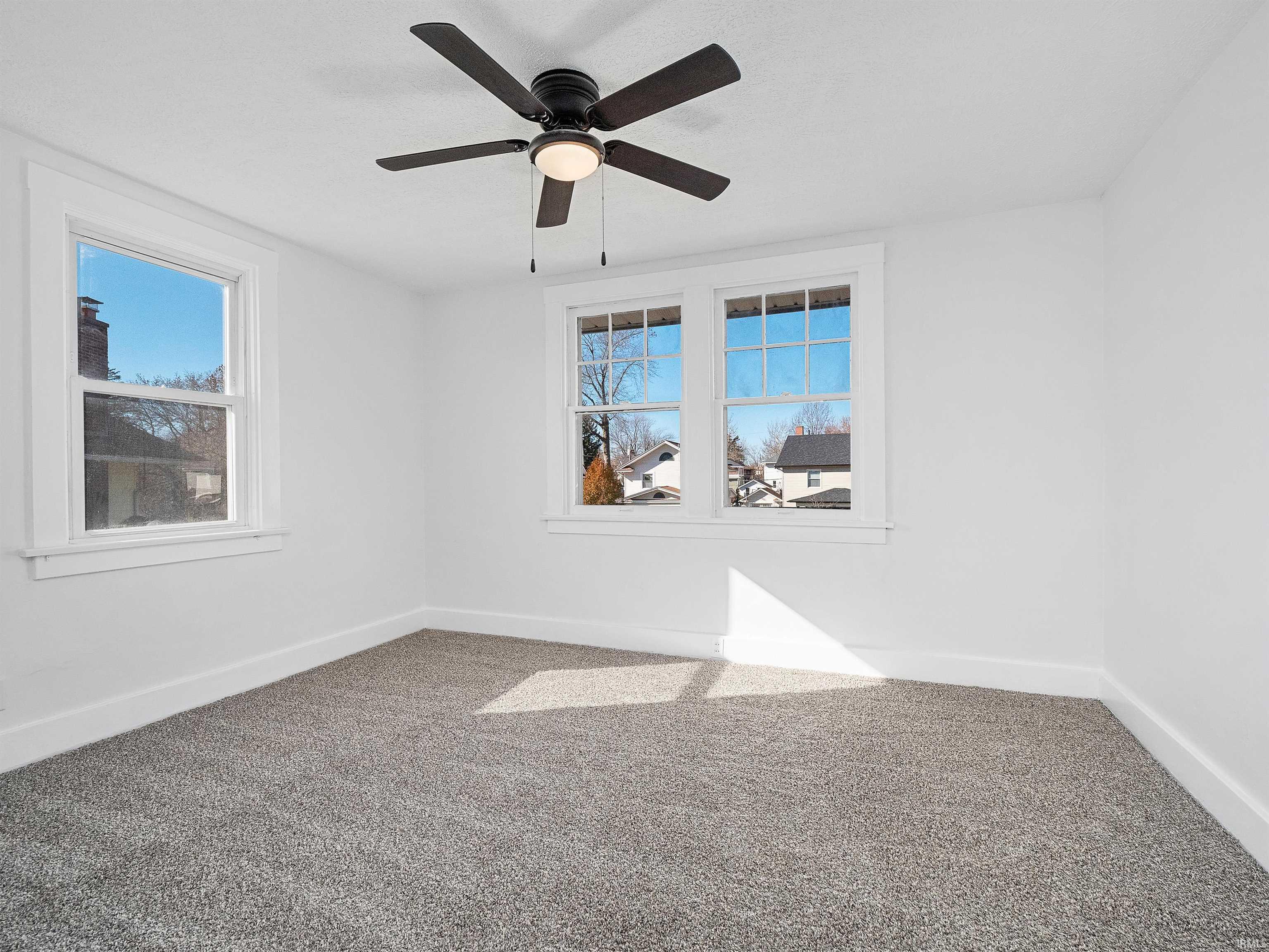 Empty room featuring carpet and a ceiling fan