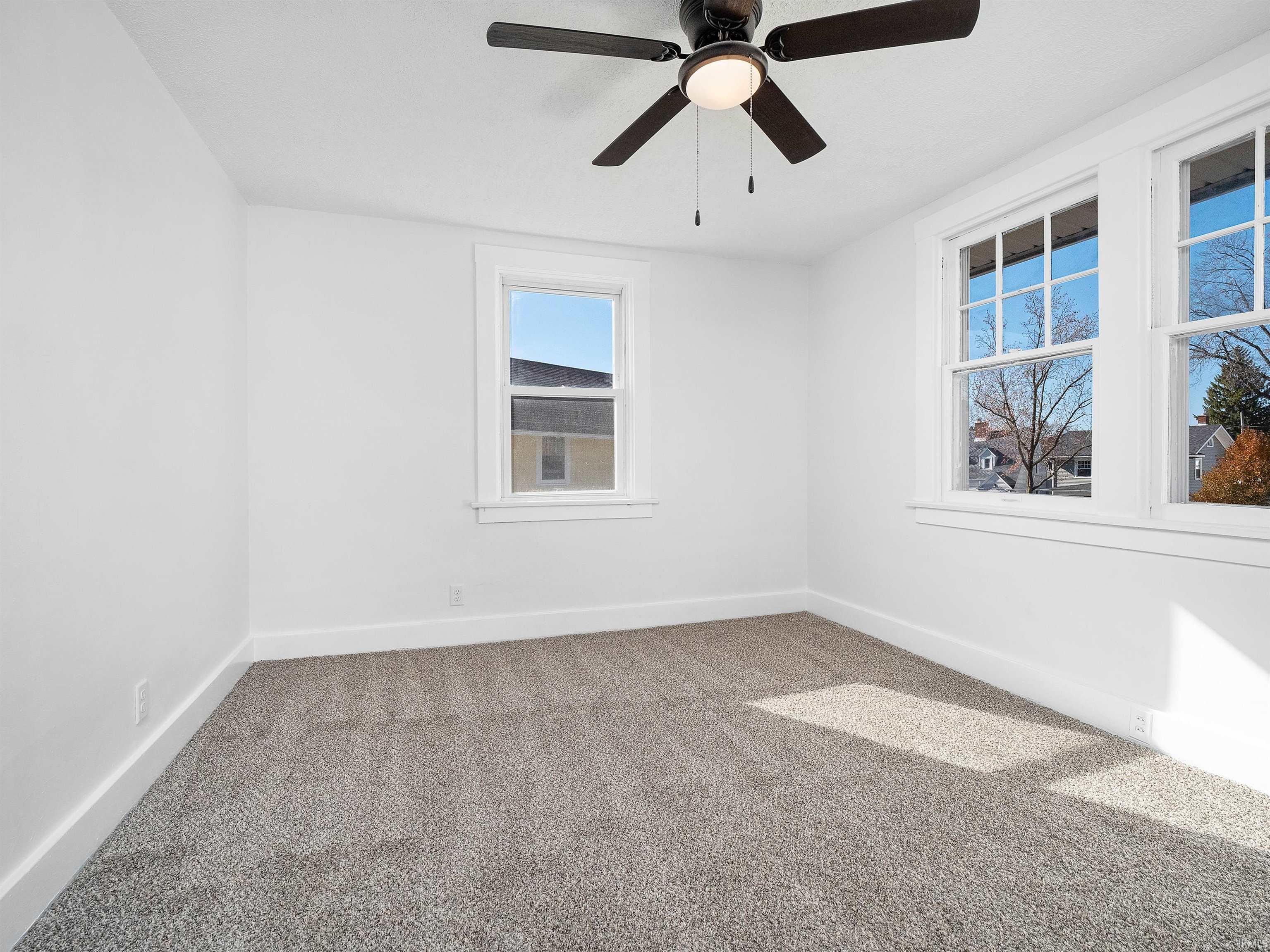 Unfurnished room featuring carpet floors and ceiling fan