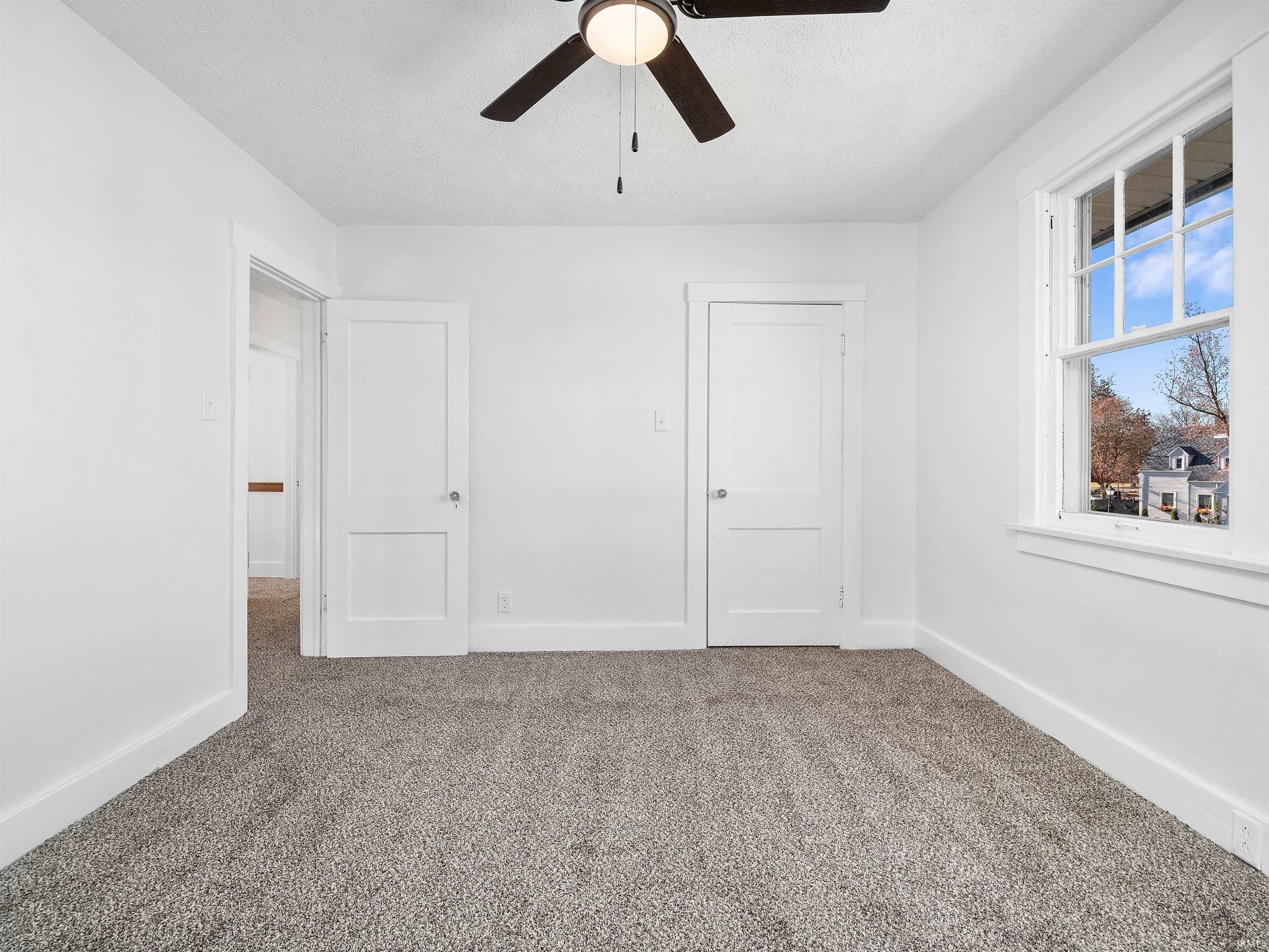 Unfurnished bedroom featuring carpet flooring and a ceiling fan