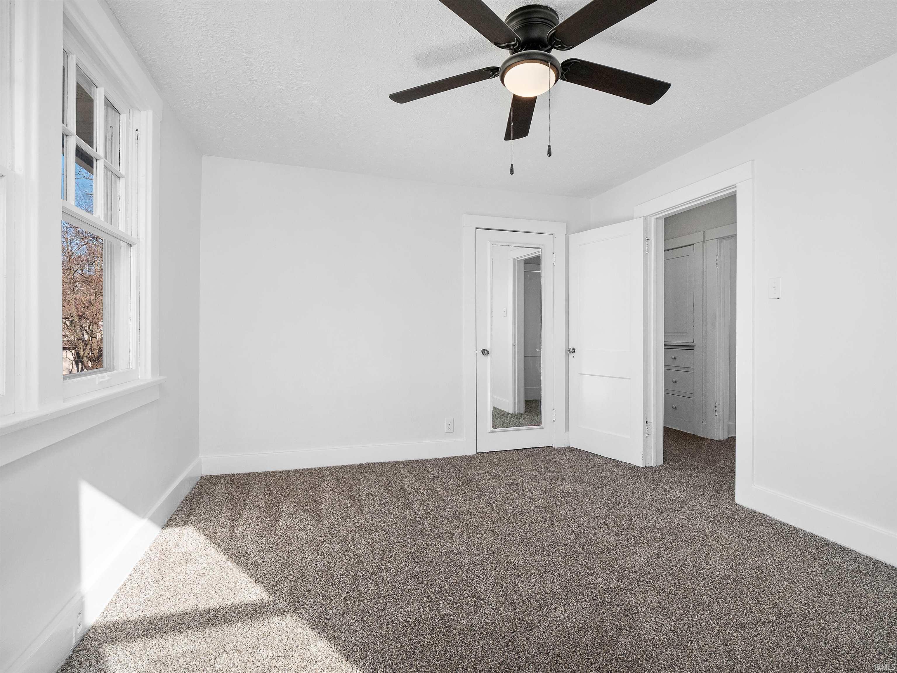 Unfurnished bedroom featuring carpet and a ceiling fan