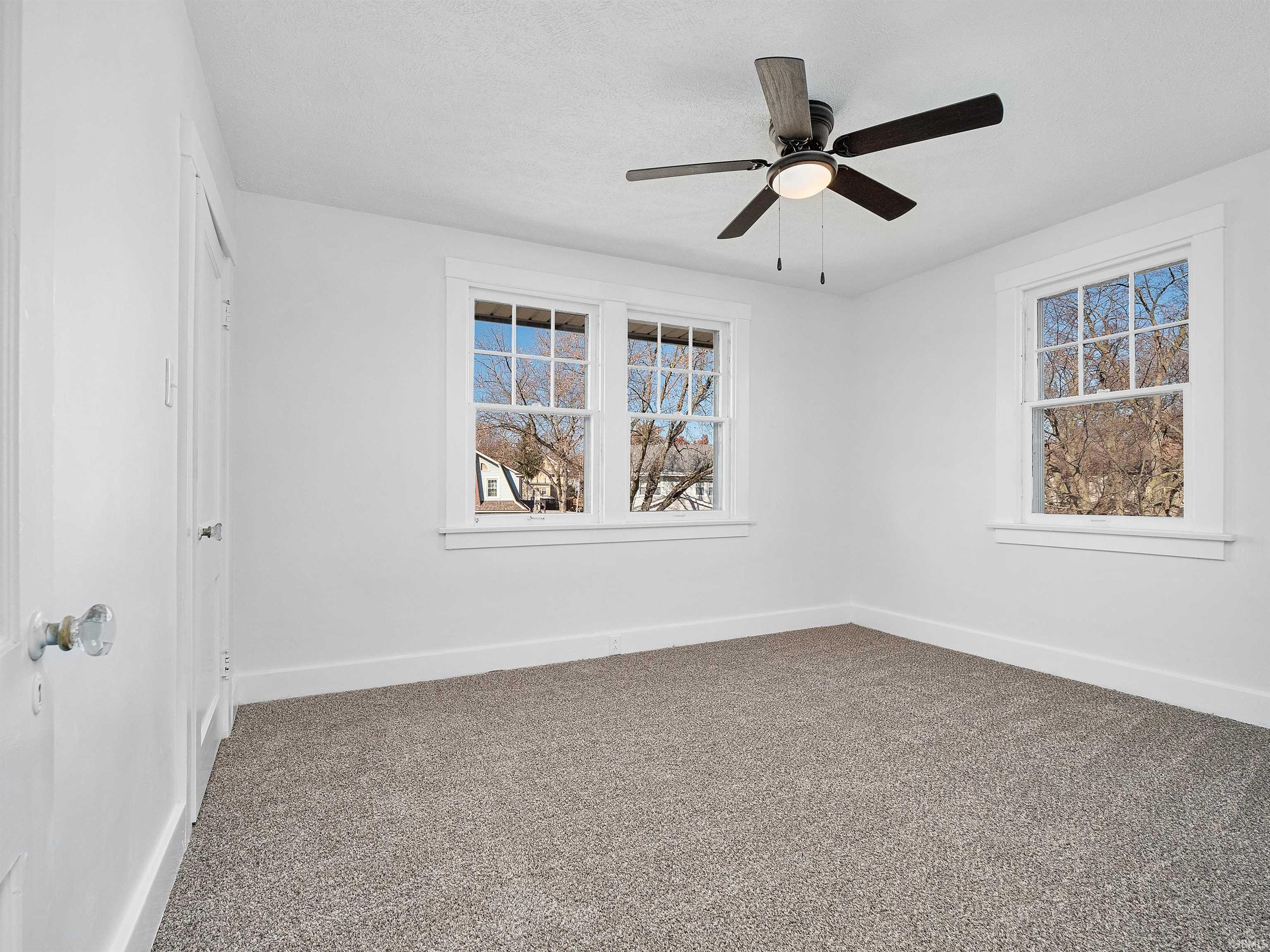Unfurnished room with carpet and a ceiling fan