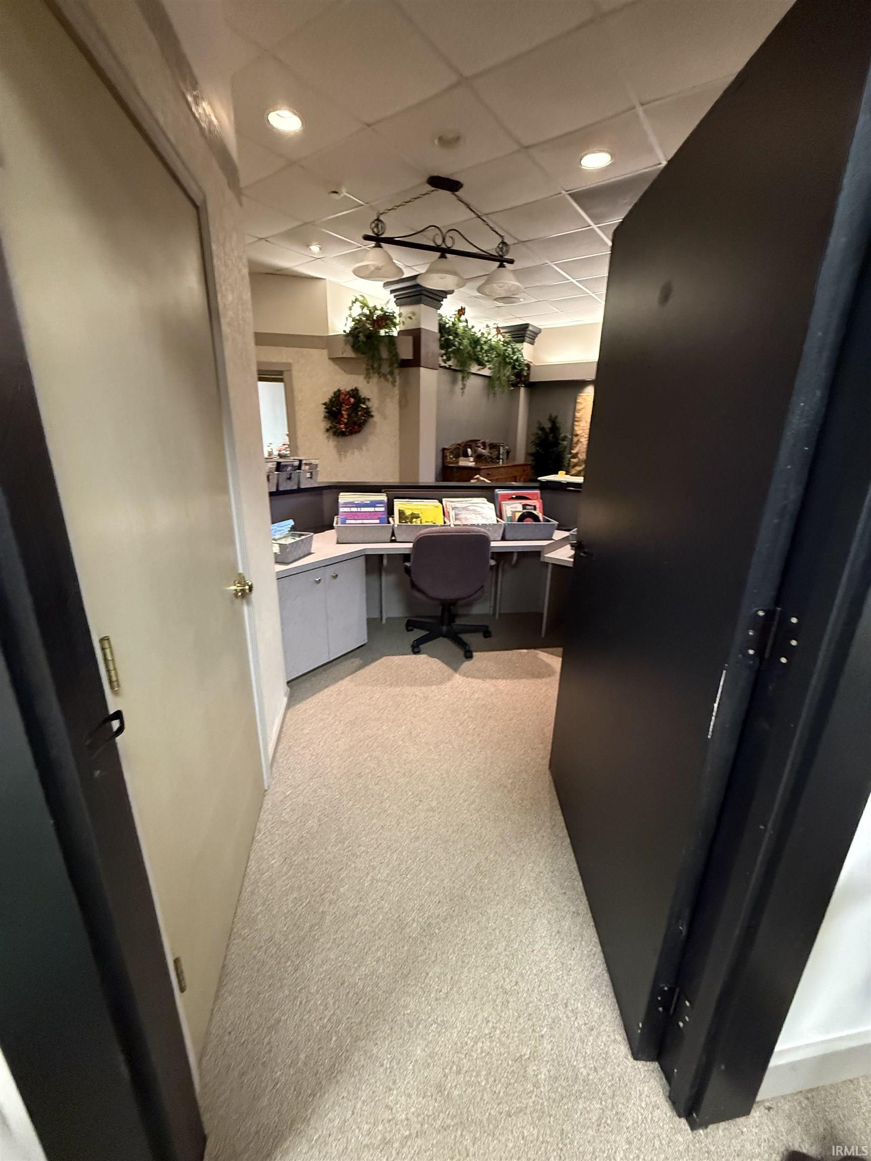 Office with a paneled ceiling and built in desk