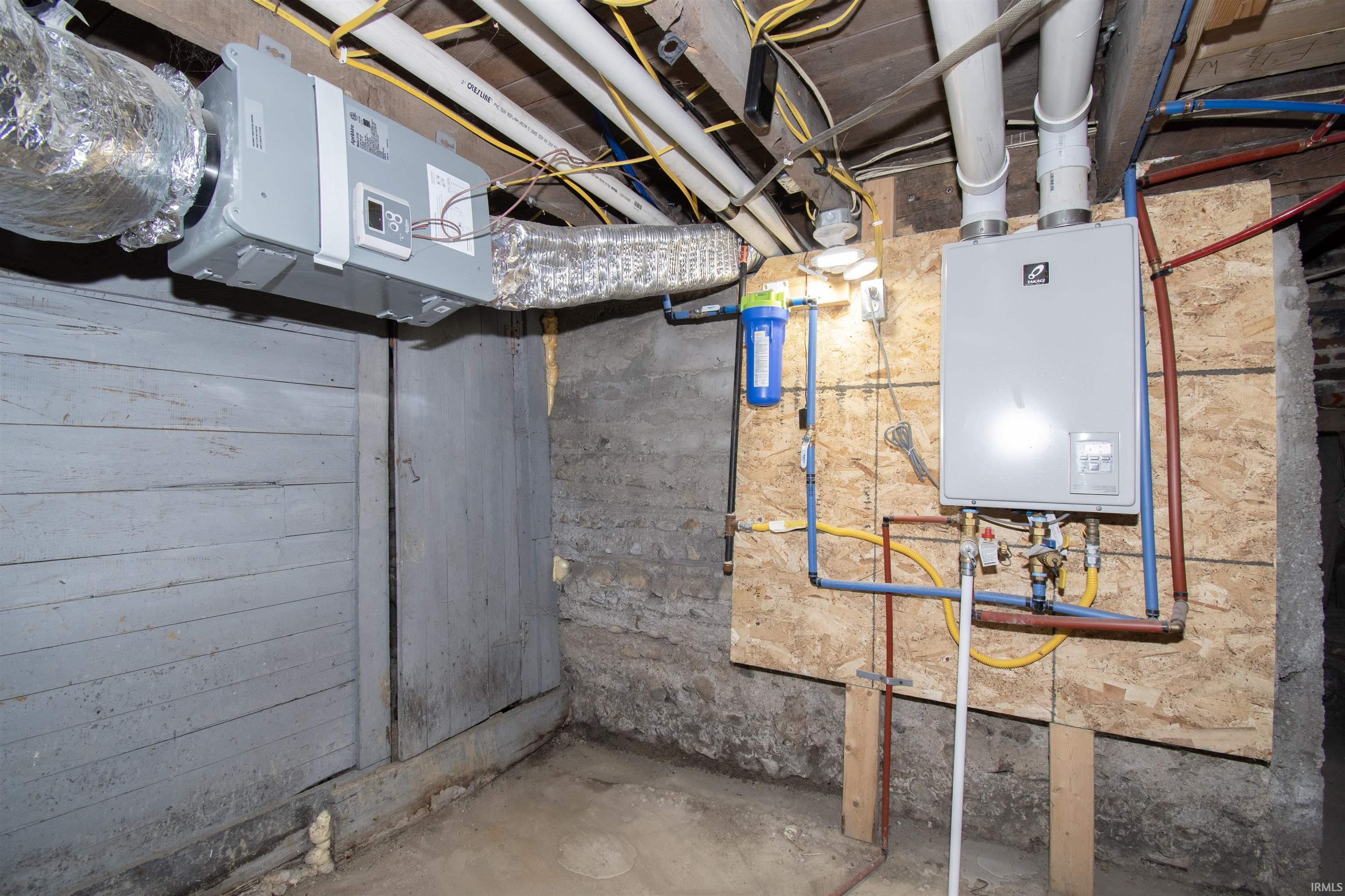 Unfinished basement featuring water heater