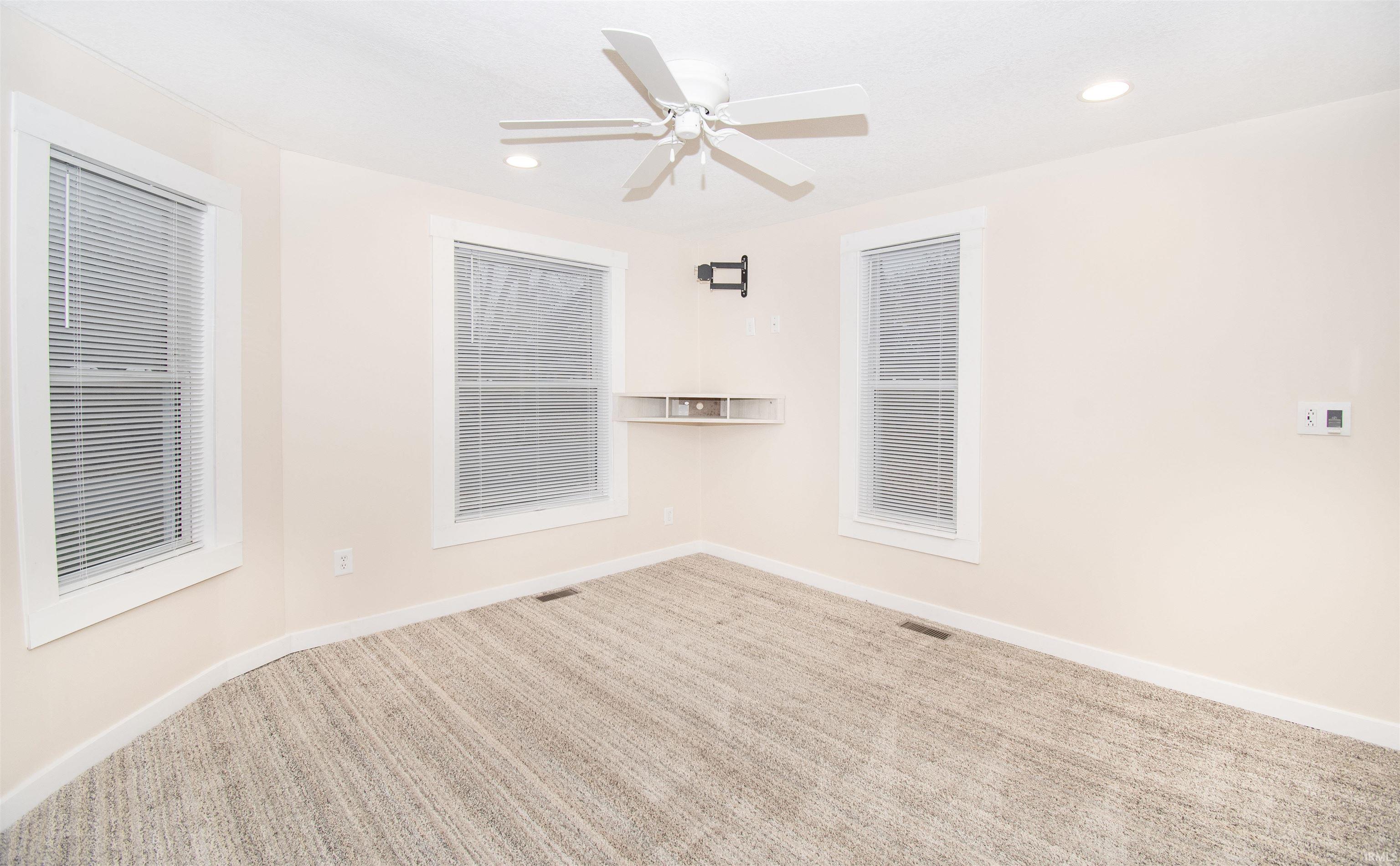 Carpeted spare room featuring recessed lighting and a ceiling fan