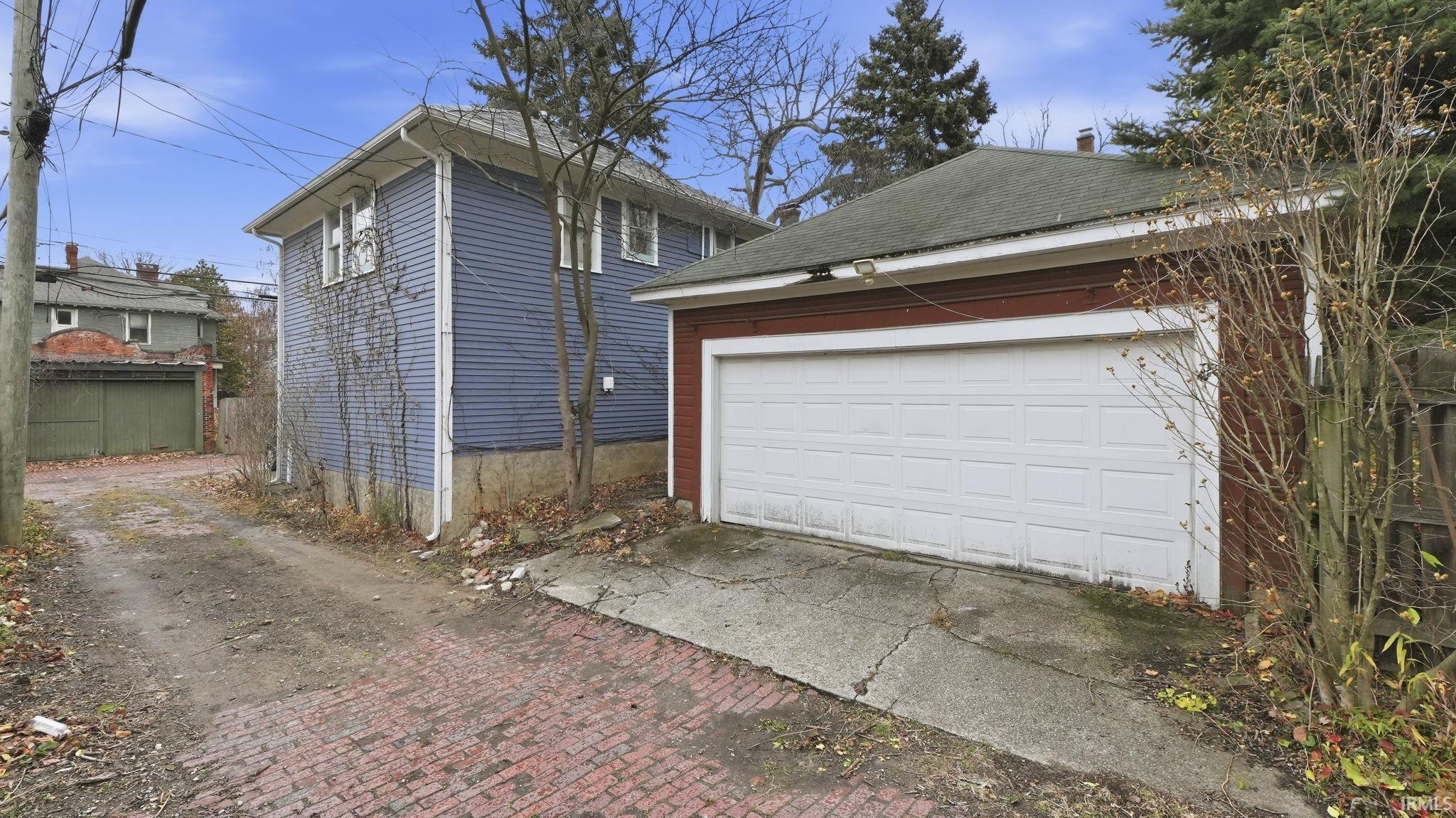 View of home's exterior with an outdoor structure and a shingled roof