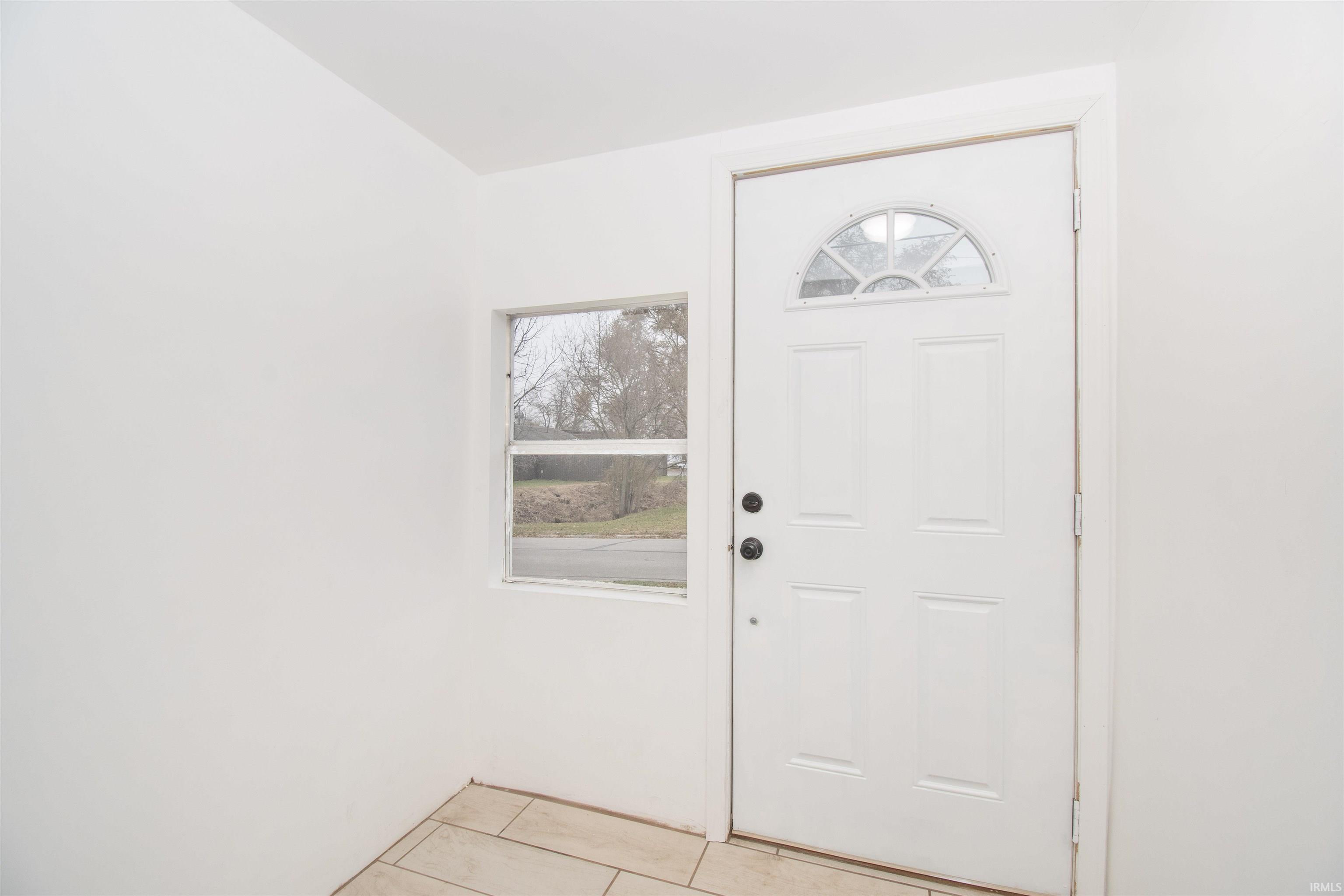 Entryway with light tile patterned floors
