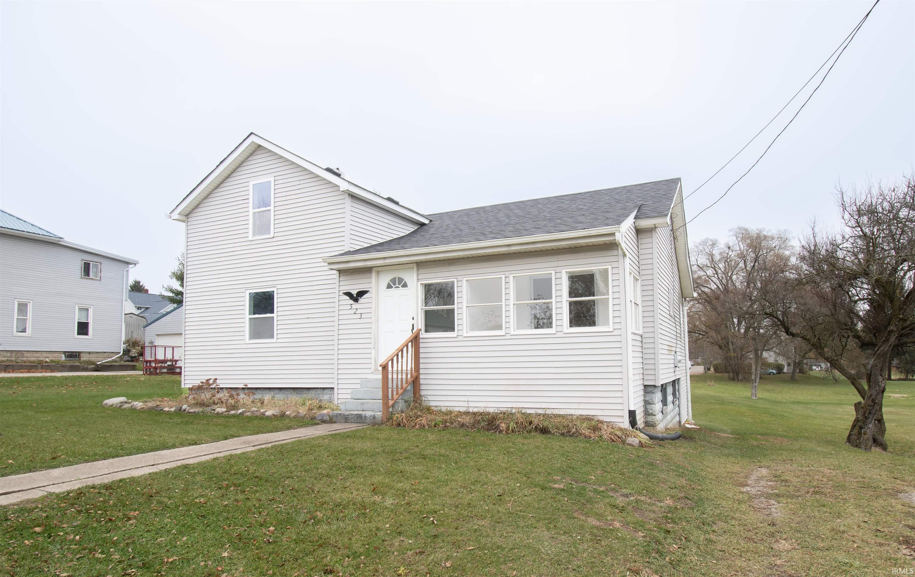 View of front of house with a front lawn, a shingled roof, and entry steps