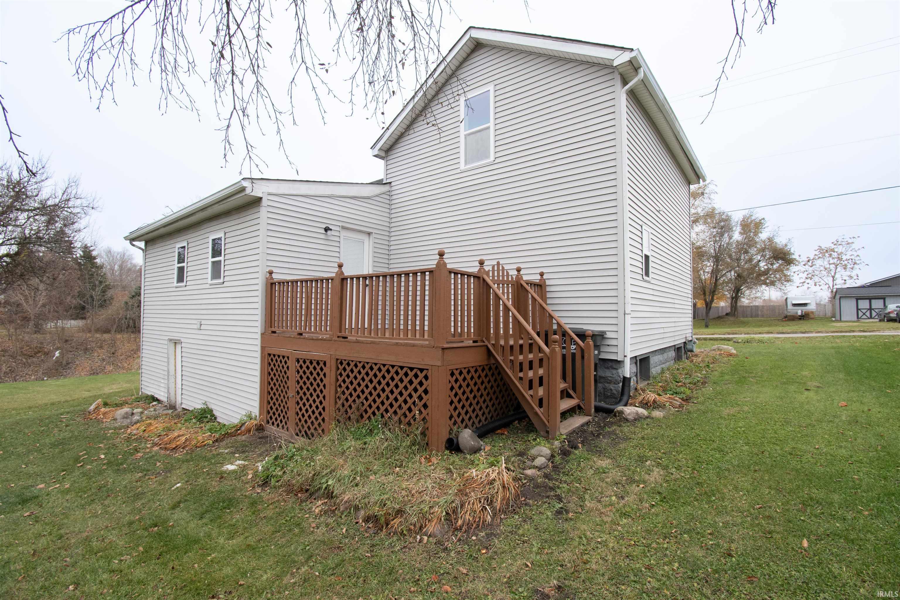 Rear view of house with a lawn and a wooden deck