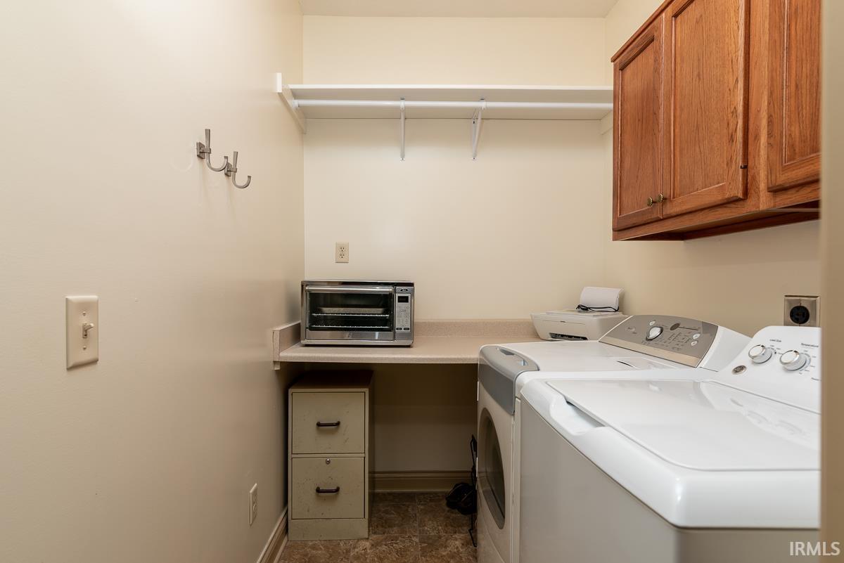 Laundry room featuring washer and clothes dryer and cabinet space