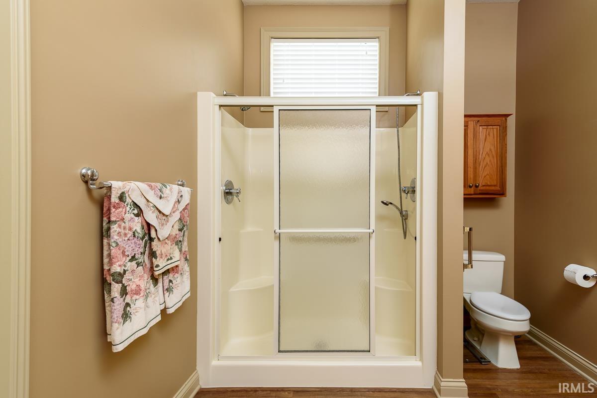 Bathroom featuring a stall shower and wood finished floors