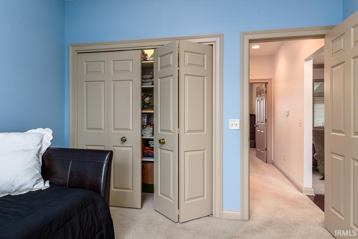 Carpeted bedroom with a closet and baseboards