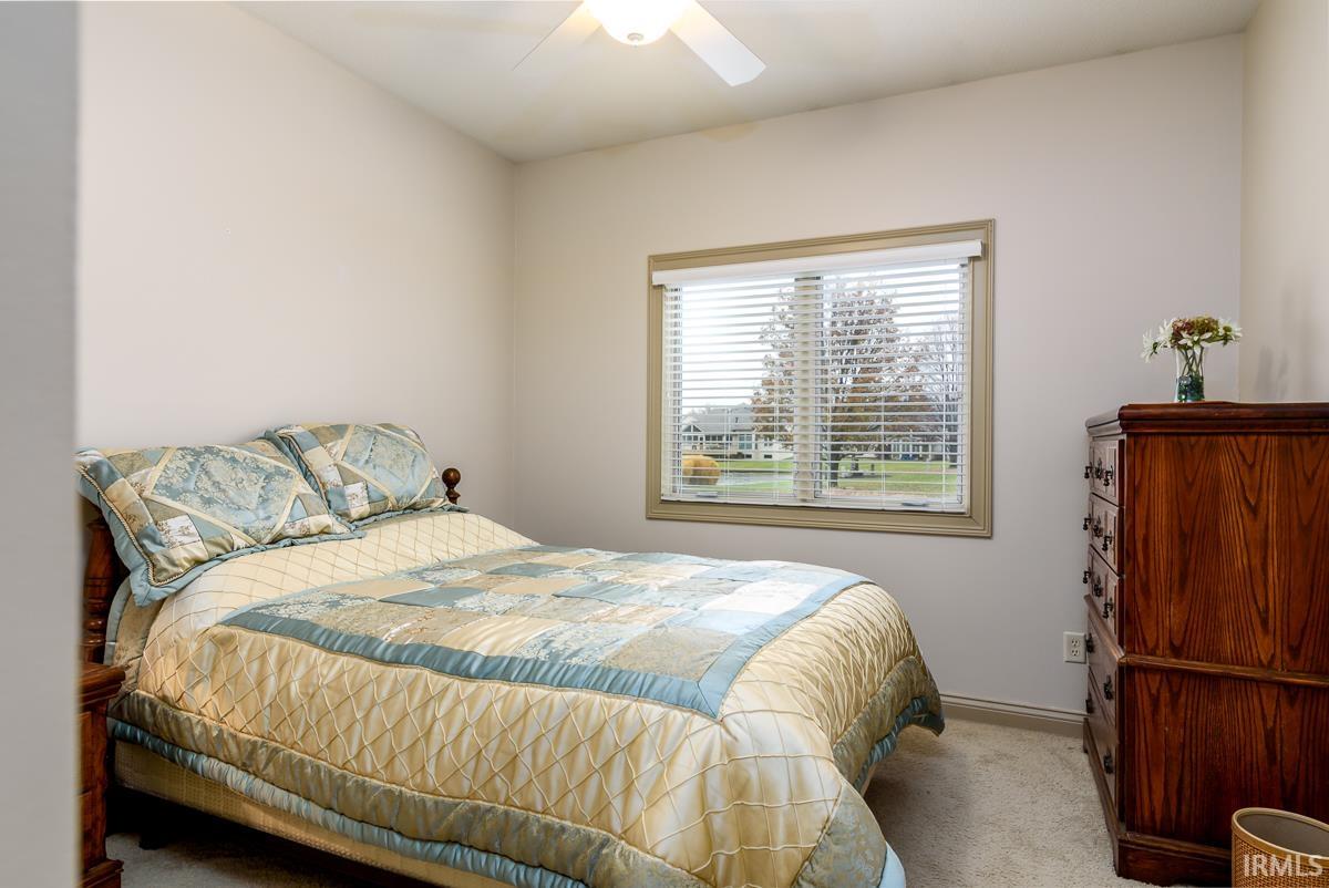 Carpeted bedroom featuring a ceiling fan and baseboards