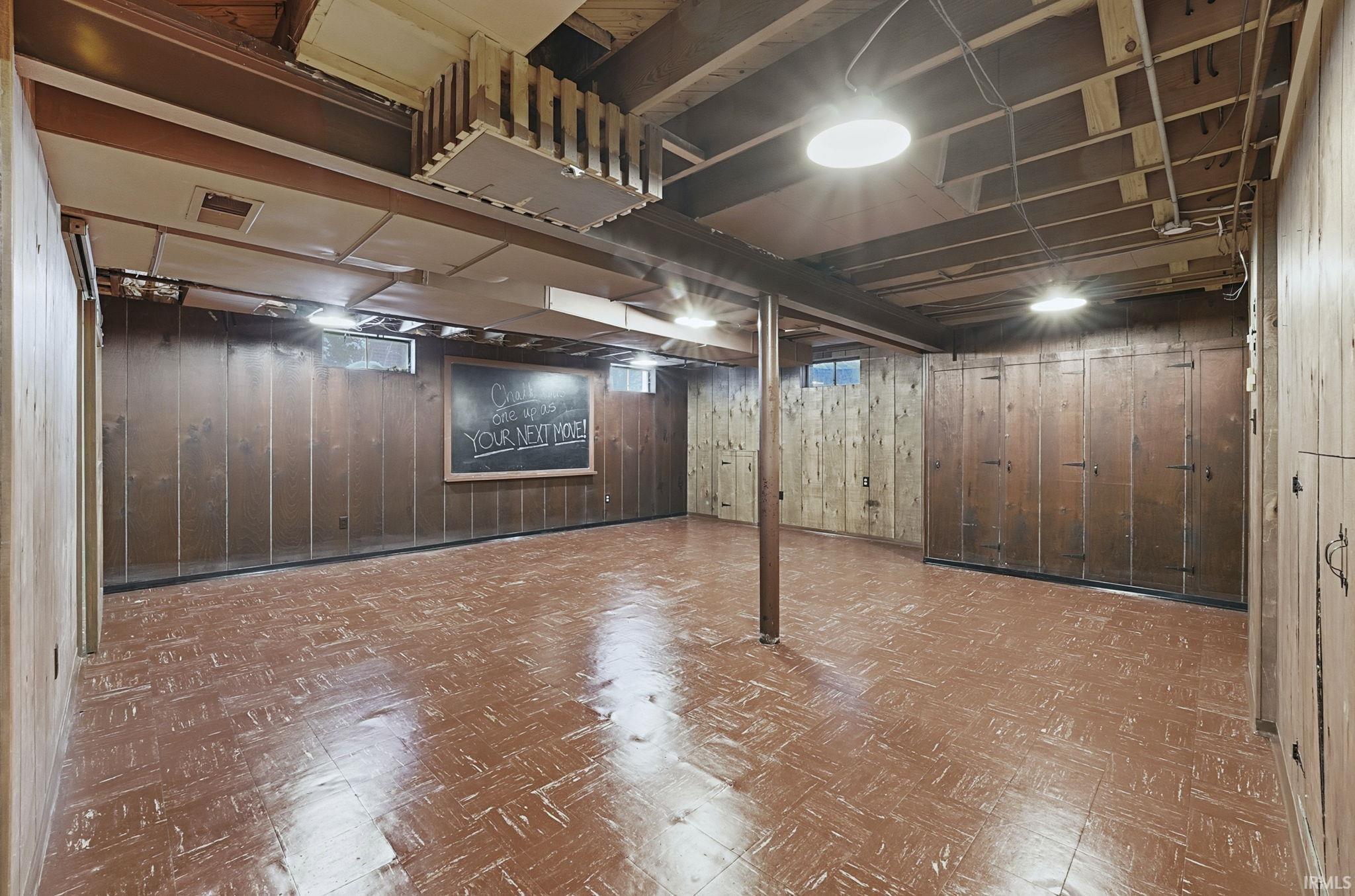 Finished basement featuring tile patterned floors and wooden walls