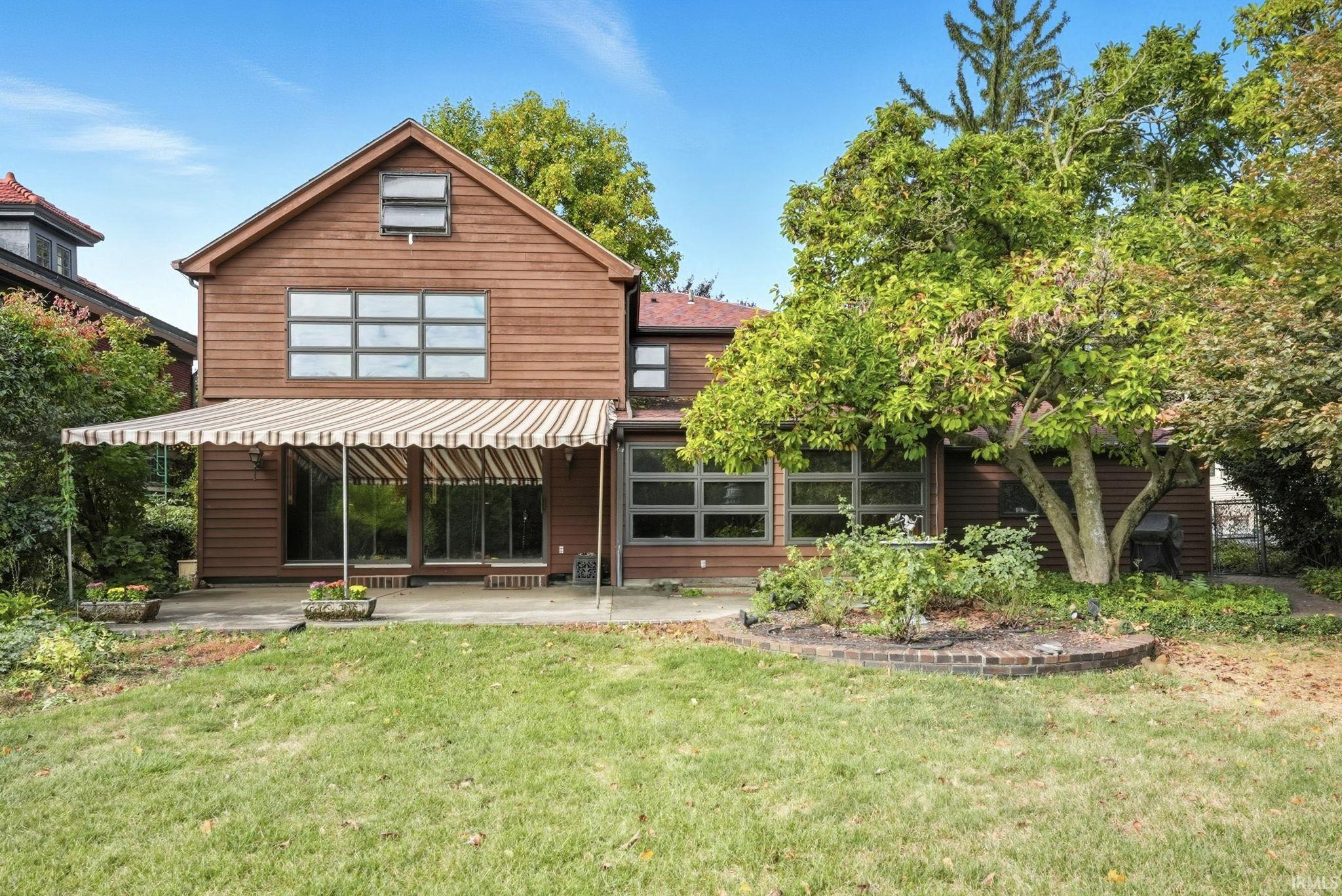 Rear view of property featuring a patio area and a lawn