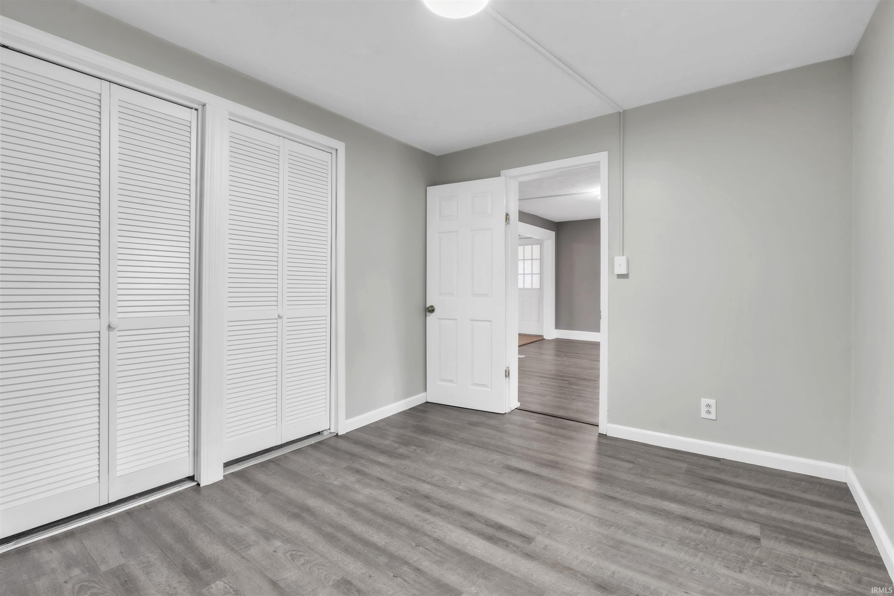 Unfurnished bedroom featuring wood finished floors and a closet