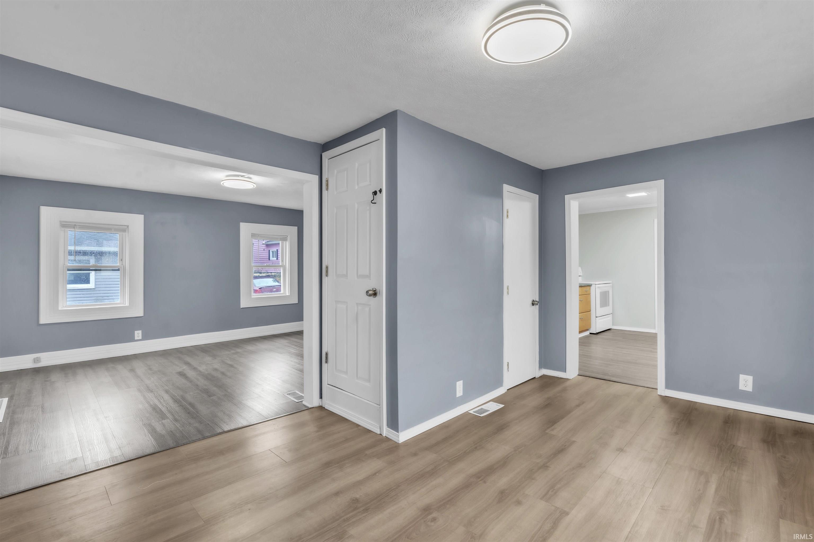 Unfurnished room with wood finished floors and washer / dryer