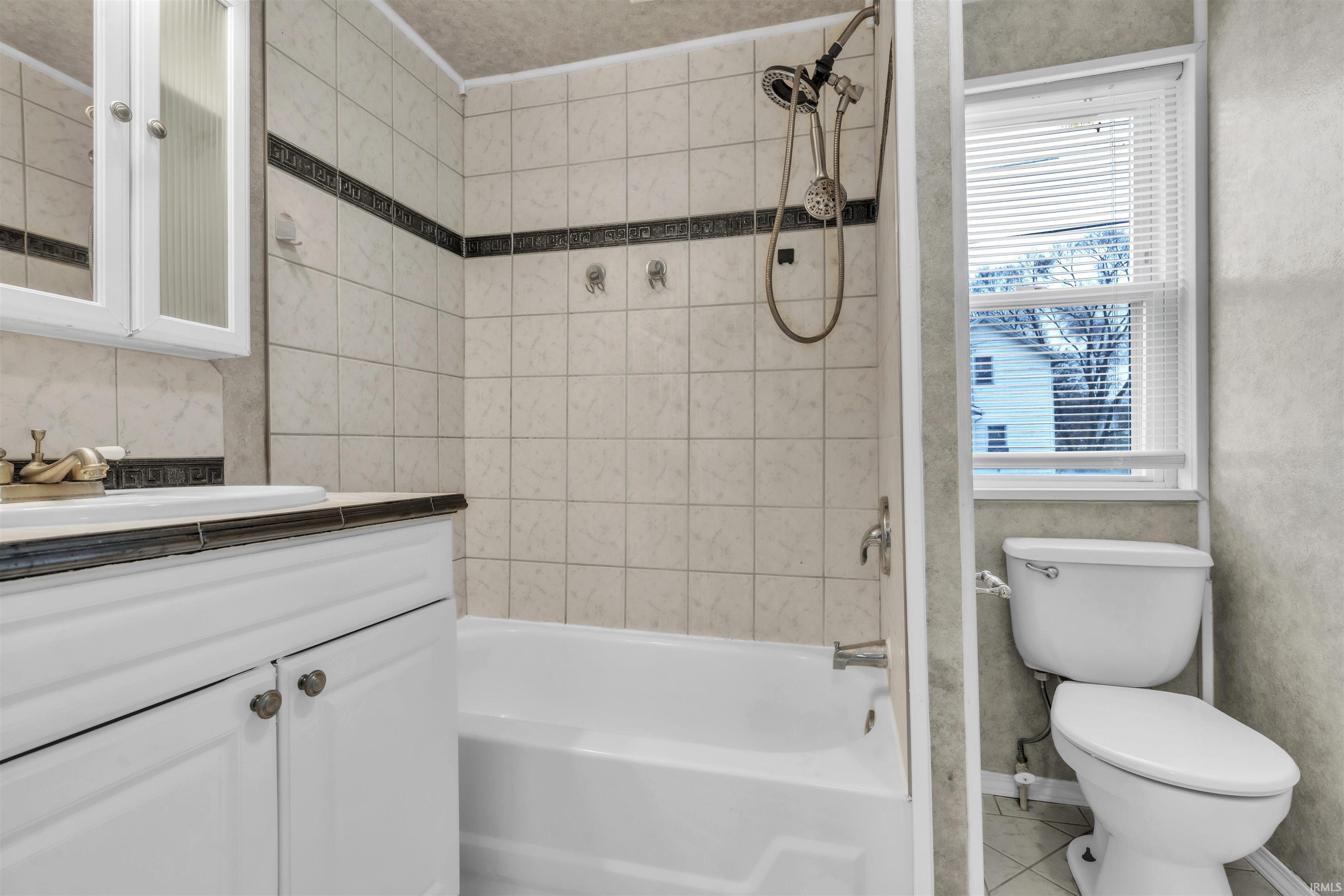 Bathroom with  shower combination, vanity, and tile patterned flooring