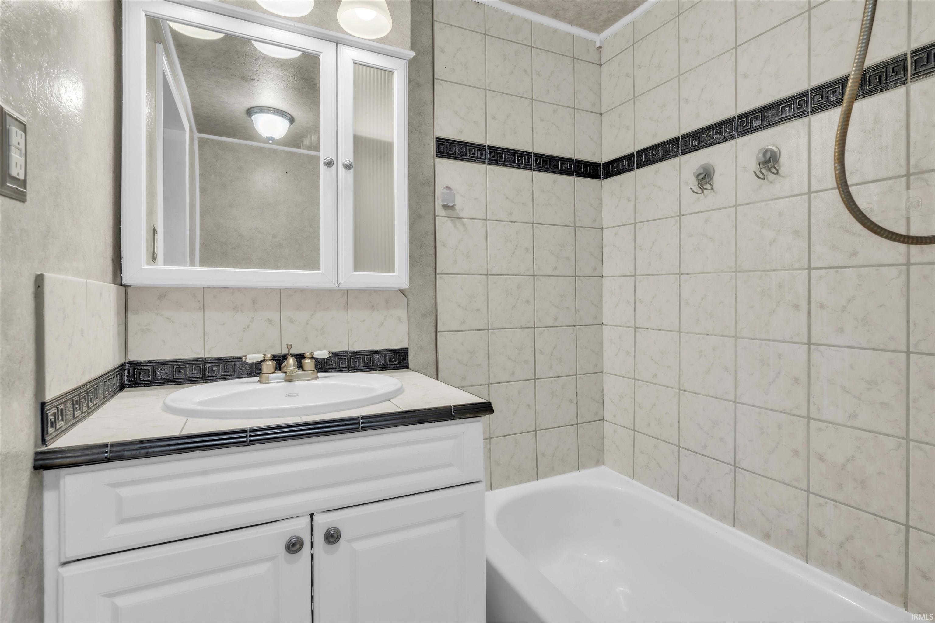 Bathroom featuring tub / shower combination and vanity