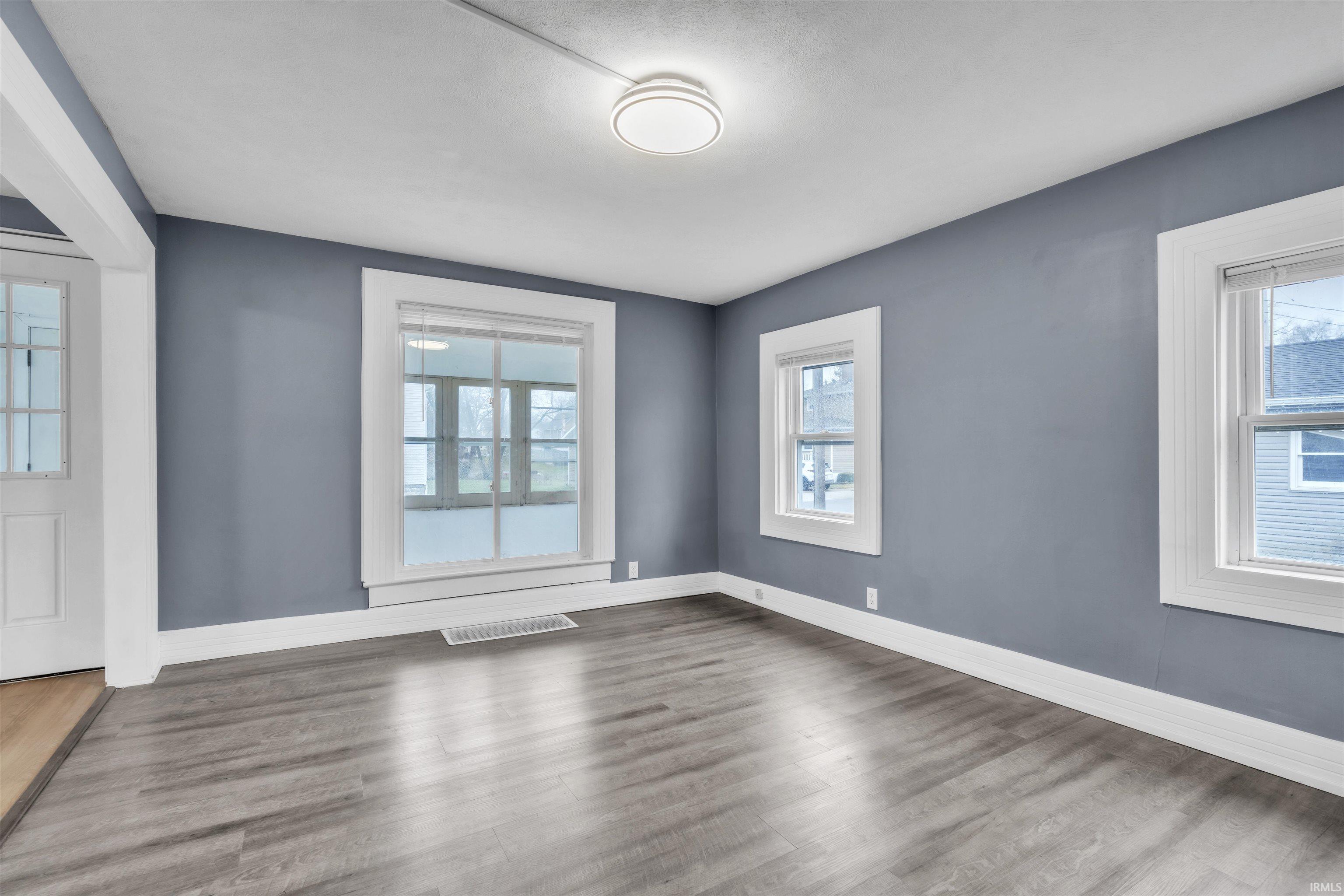 Unfurnished room with plenty of natural light and wood finished floors