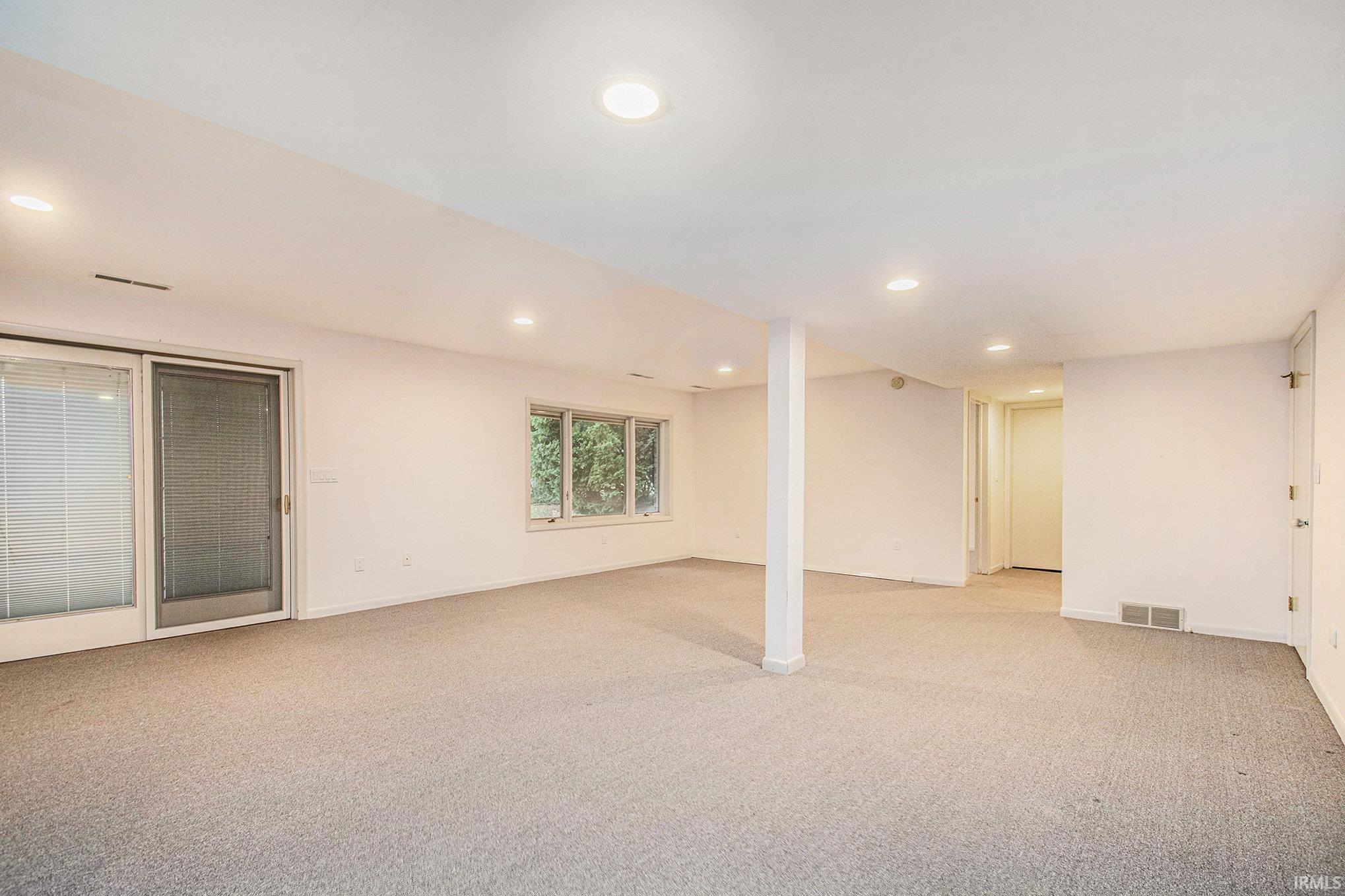 Basement with light colored carpet and recessed lighting