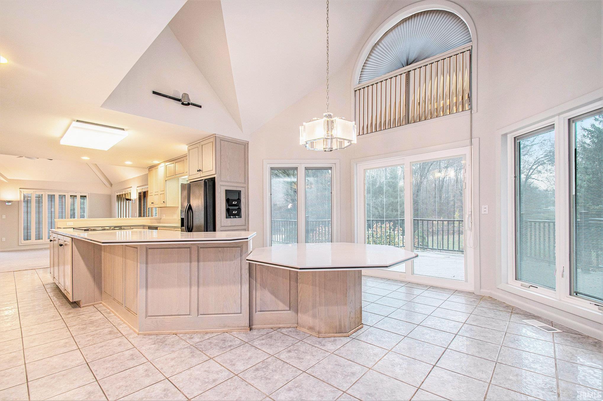 Large counter table for eating in the kitchen or the breakfast area. Rear view of the property with large windows and open to the deck.