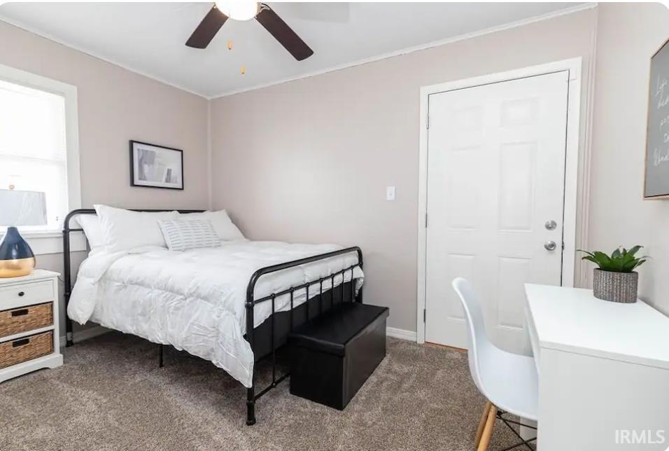 Bedroom featuring dark carpet and ceiling fan