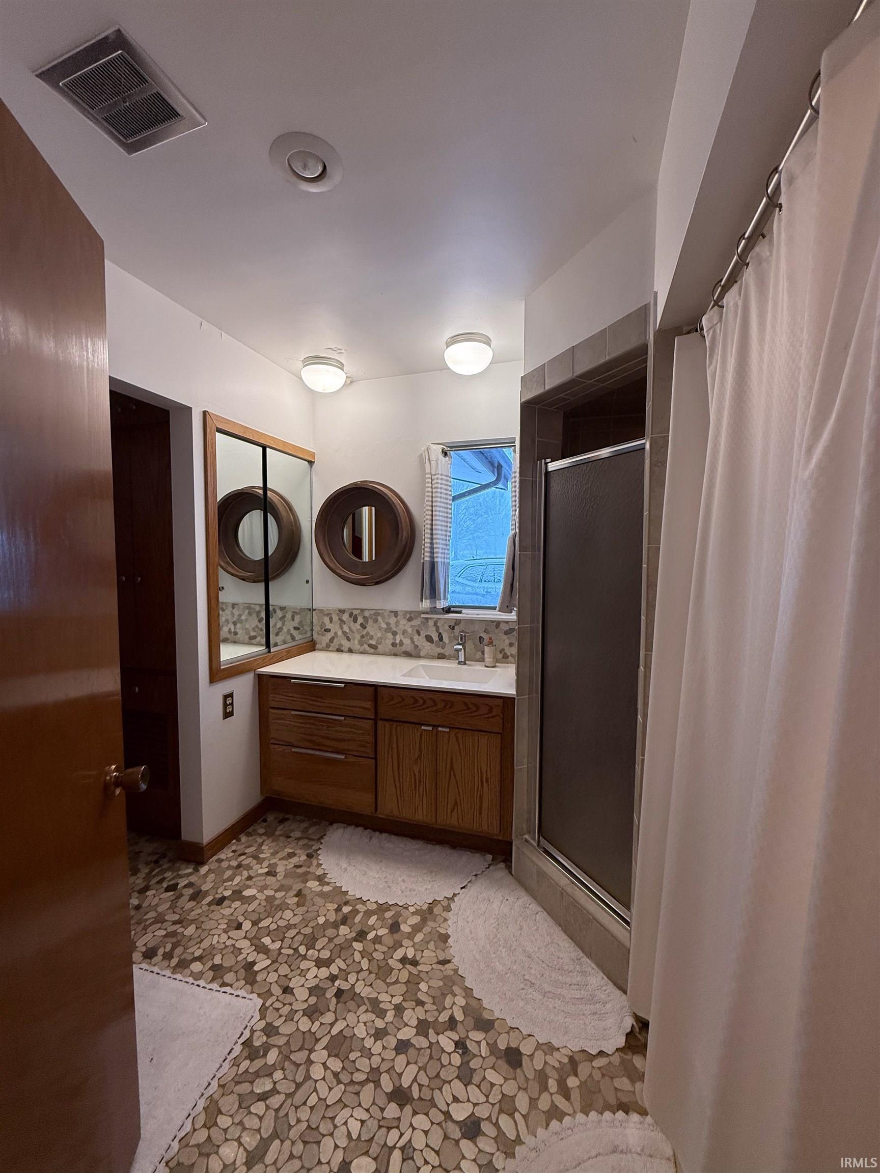 Bathroom with a shower stall and vanity