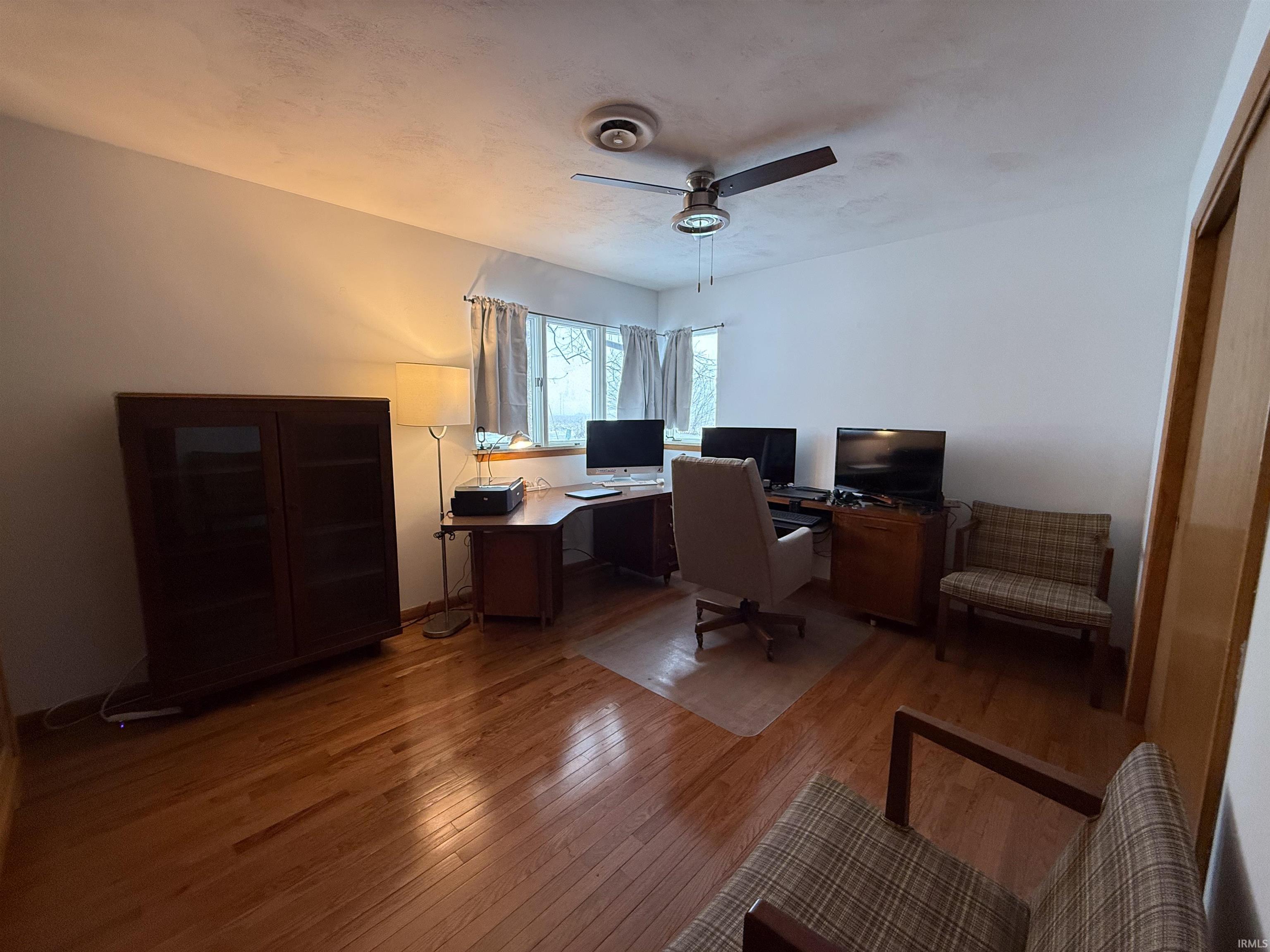 Home office featuring hardwood / wood-style flooring and ceiling fan