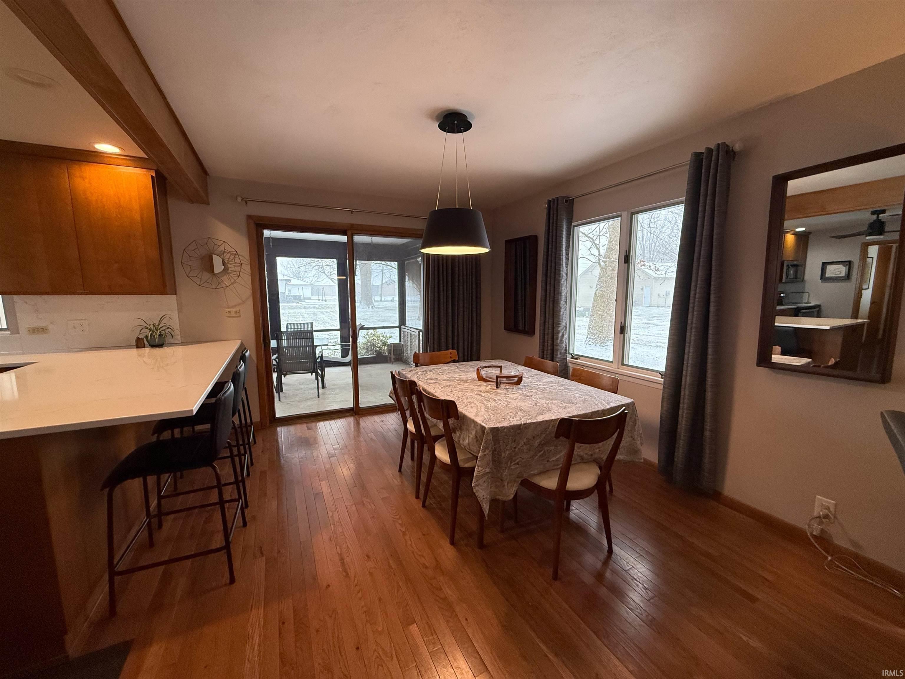 Dining area with dark wood finished floors and healthy amount of natural light