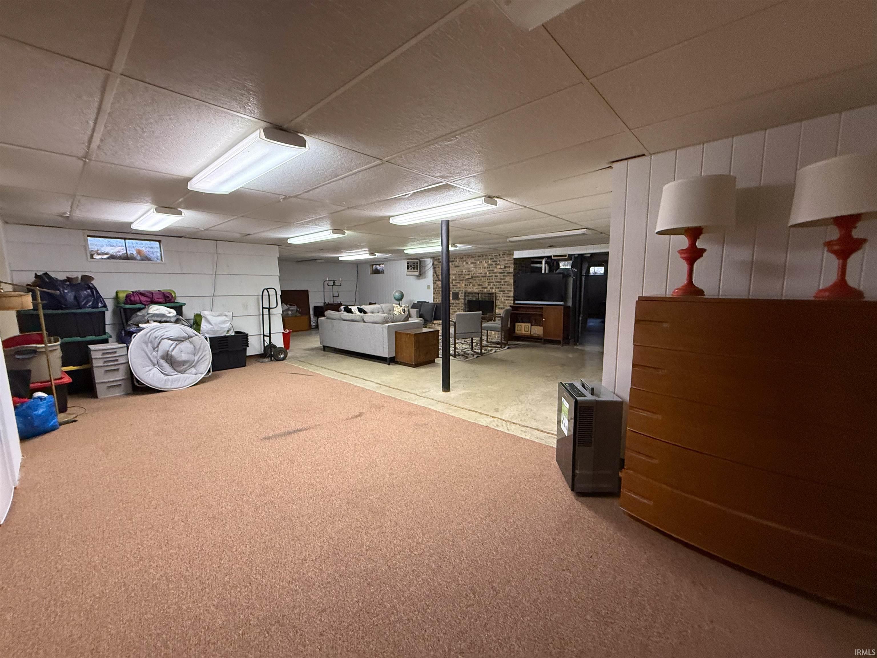 Below grade area with a drop ceiling and carpet flooring