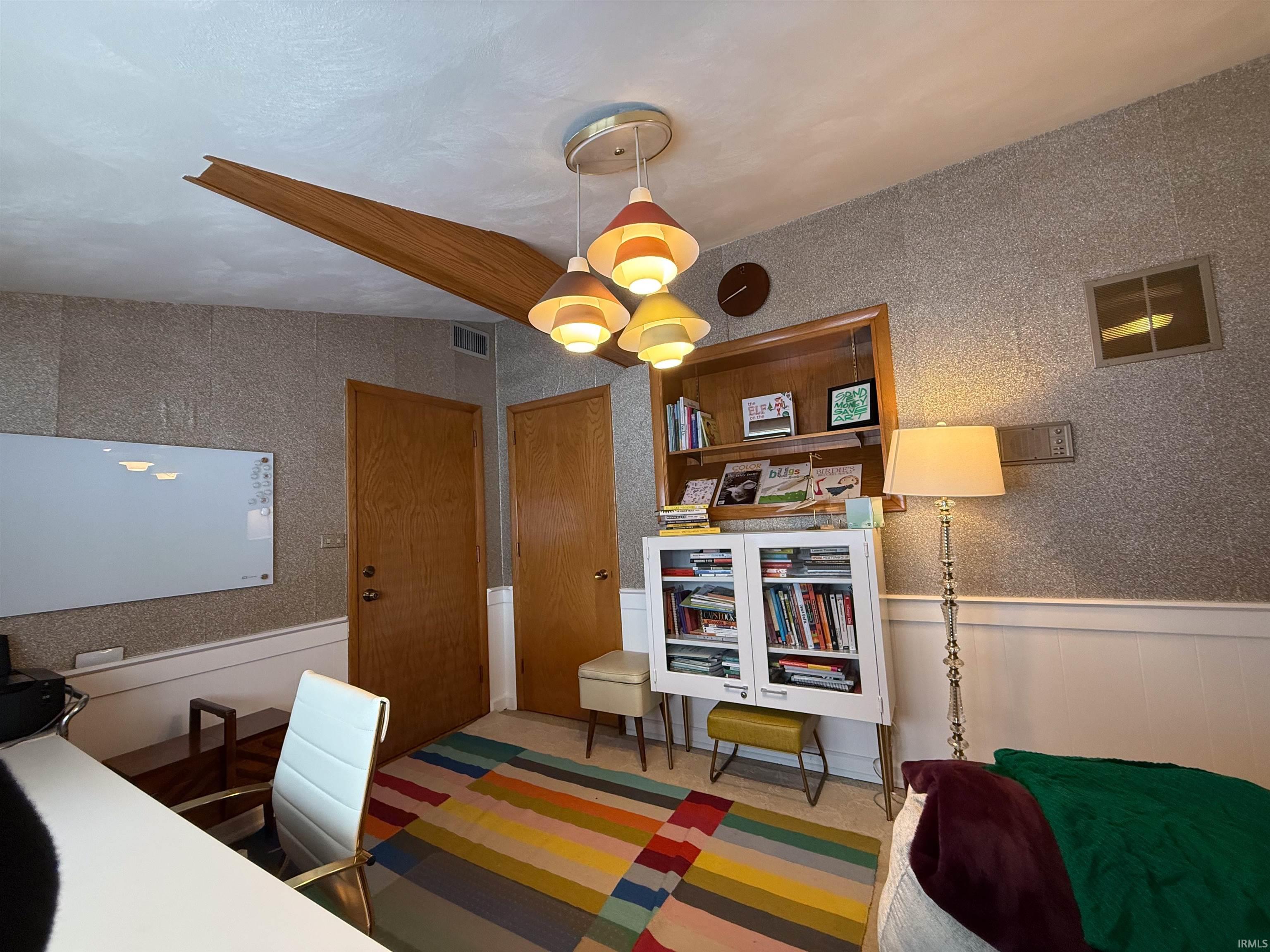 Dining area featuring a wainscoted wall, wallpapered walls, and a desk