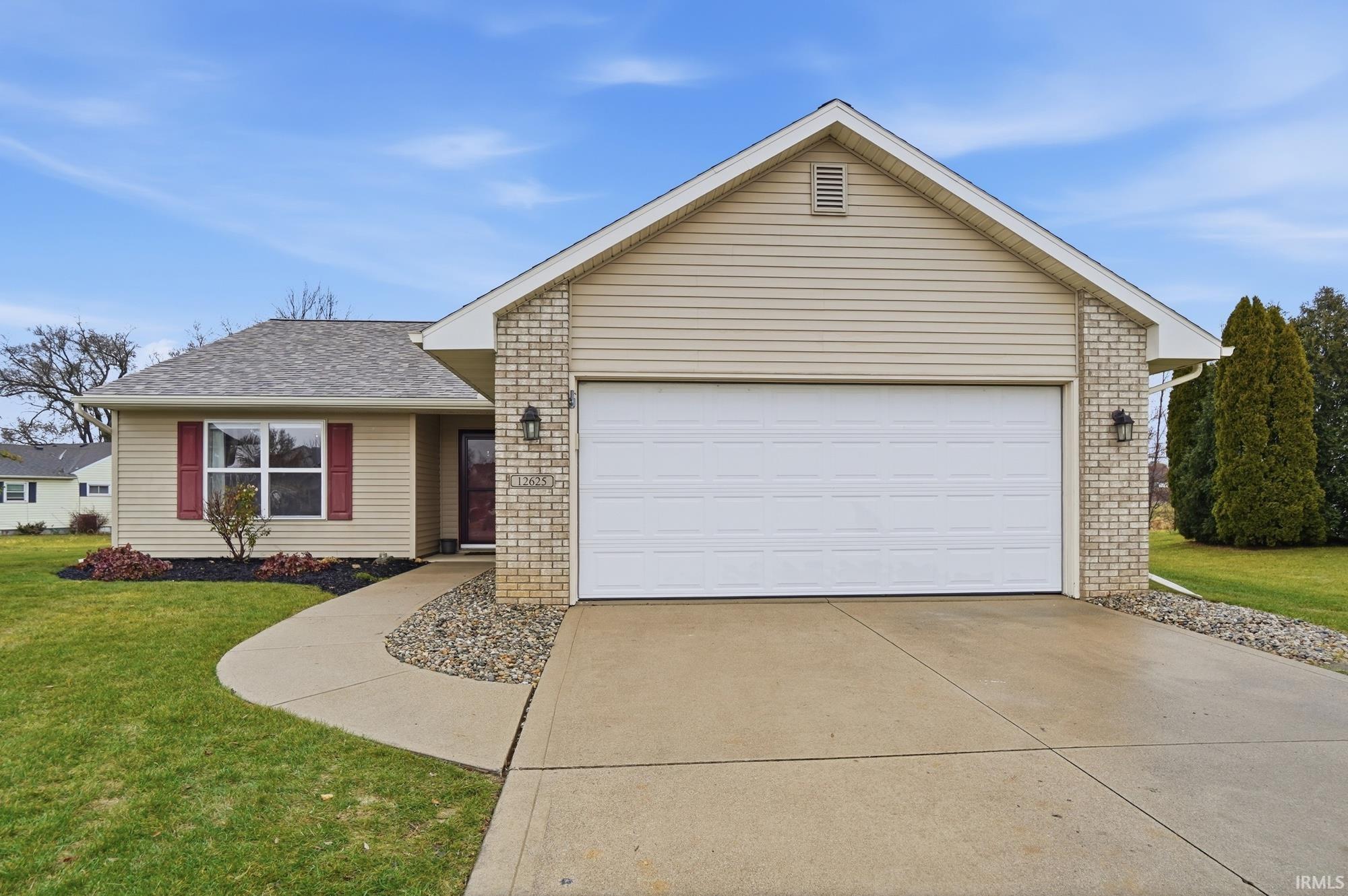 Ranch-style home featuring a front lawn, brick siding, concrete driveway, and roof with shingles