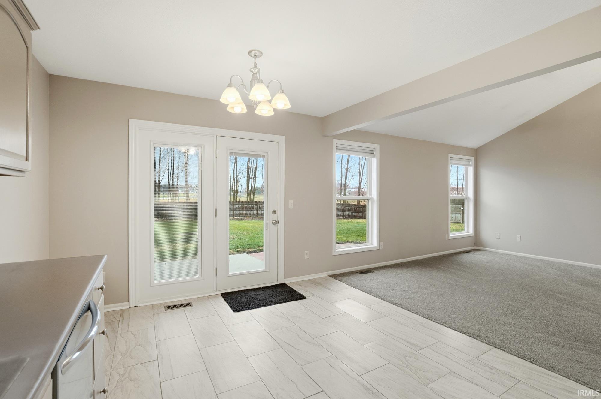 Doorway featuring a chandelier and lofted ceiling